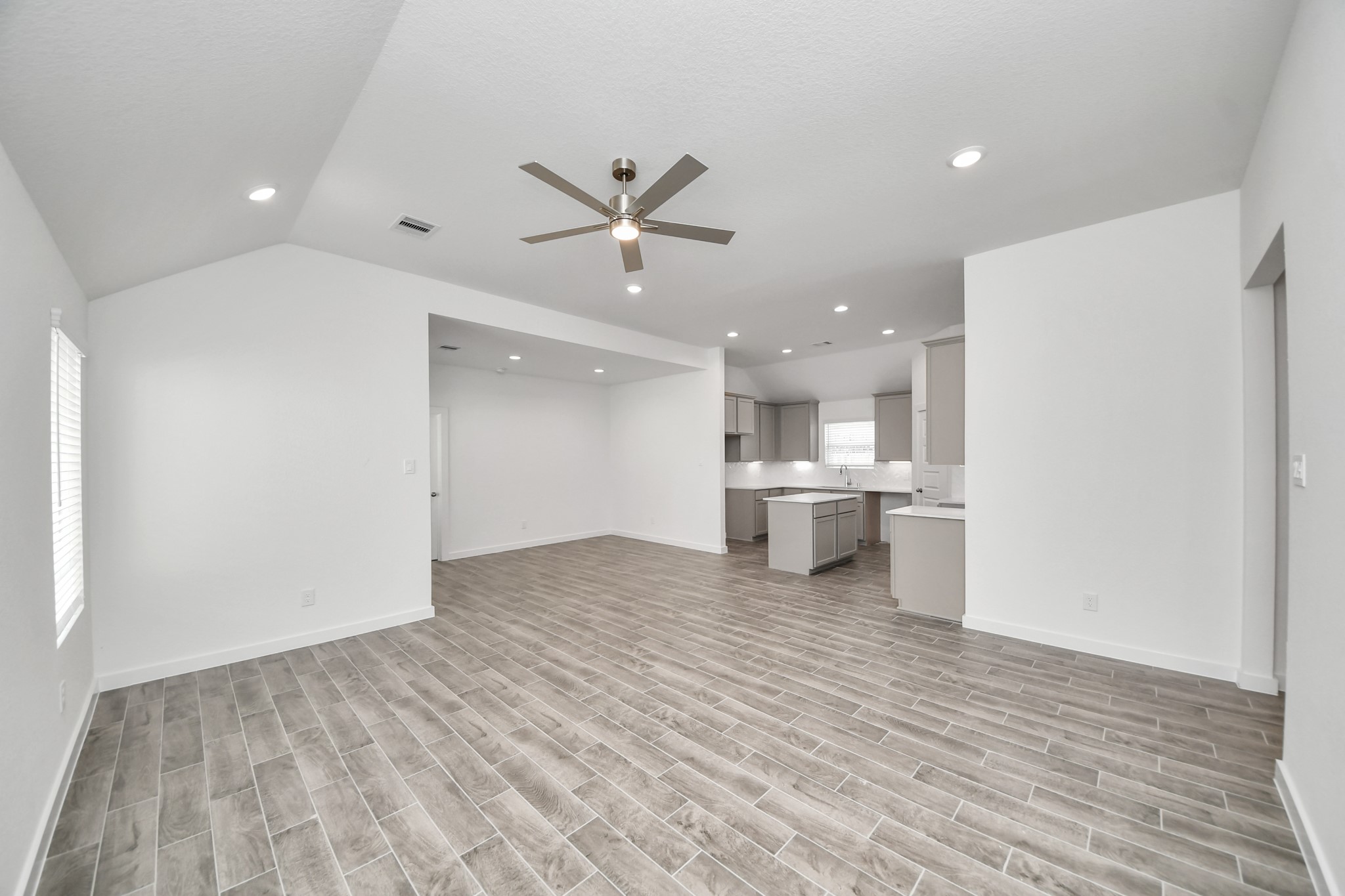 Family room flooded with natural light through the expansive windows.  The premium tile flooring adds a touch of luxury to the space, creating the perfect setting for relaxing moments and cherished gatherings with loved ones. Sample photo of completed home with similar floor plan. Actual colors and selections may vary.