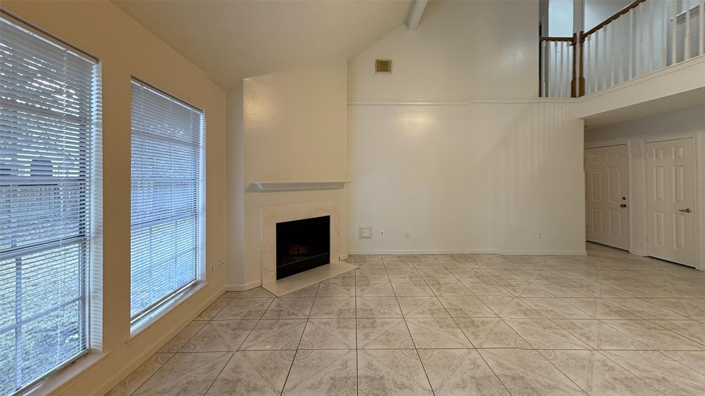 high ceiling family room with fireplace.