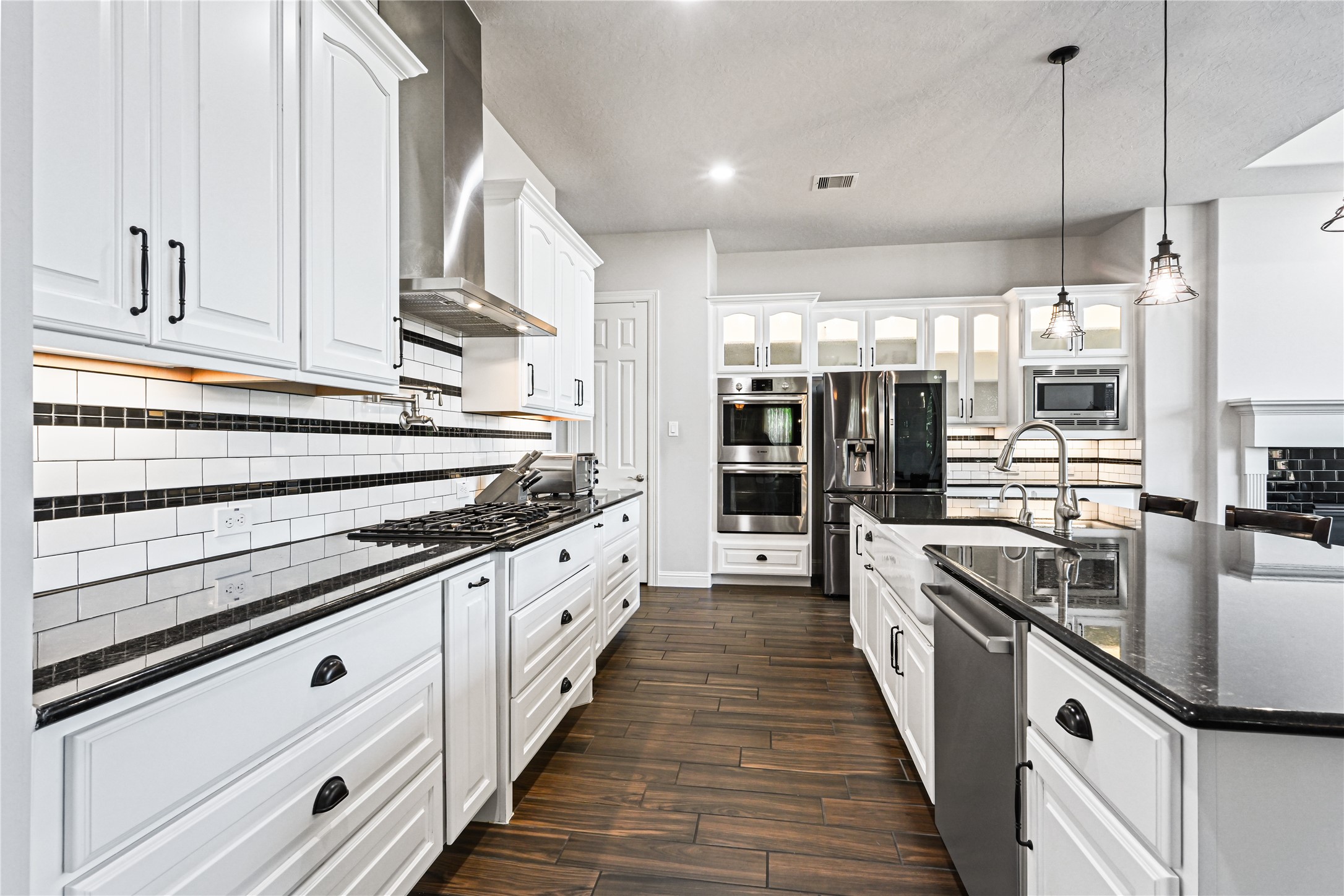 Just look at those stunning custom cabinets! This gourmet kitchen continues to impress with a deep, wide farmhouse sink, pull-out kitchen faucet, built-in Bosch stainless steel appliances, spacious walk-in pantry & beautiful, carefree wood-look plank tile flooring. Custom, custom, customevery detail was thoughtfully designed to make this kitchen as functional as it is breathtaking!