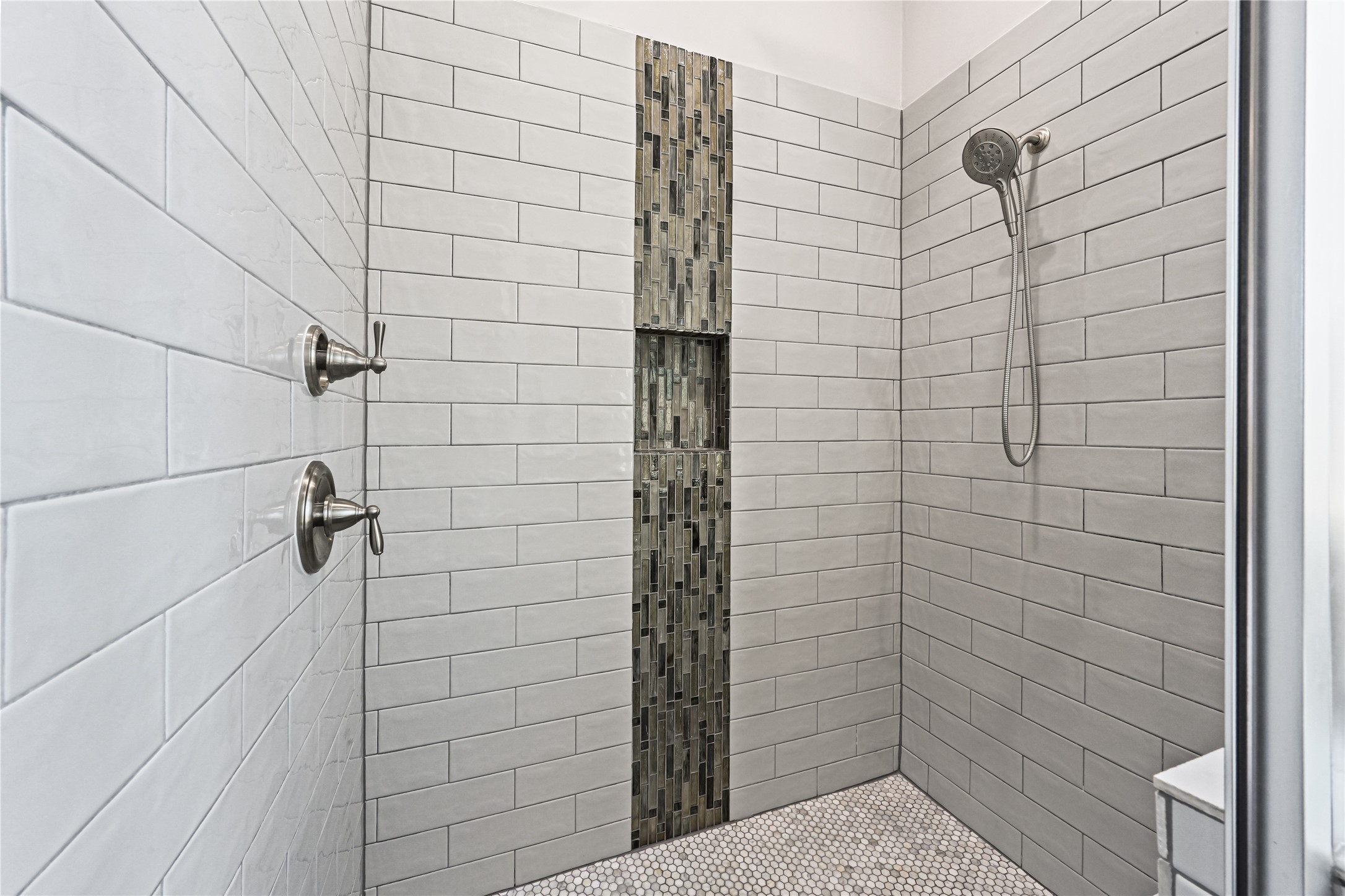 WOW! Step into this massive walk-in shower beautifully finished with custom designer tile from top to bottom and gorgeous coordinating tile flooring. Spacious, luxurious & thoughtfully designed, this impressive shower completes the spa-like feel of your private primary bathroomsimply stunning!
