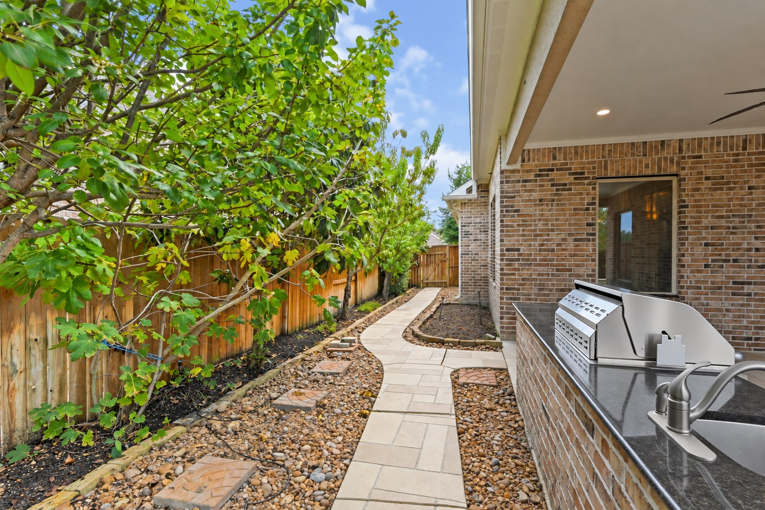 Stroll along the beautiful custom walkway accented with gorgeous travertine tile and surrounded by lush landscaping & fruit trees! Every detail of this private backyard retreat was thoughtfully designed to create a peaceful, inviting outdoor escape. Simply beautiful!