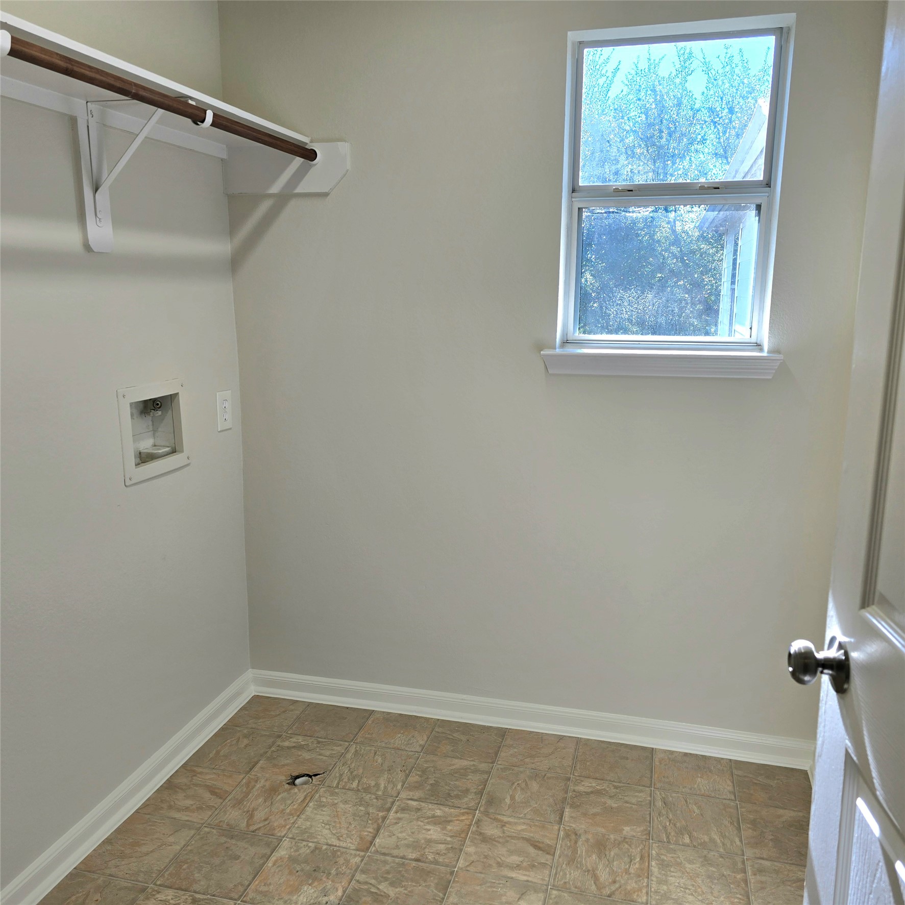 Spacious laundry room with shelving.