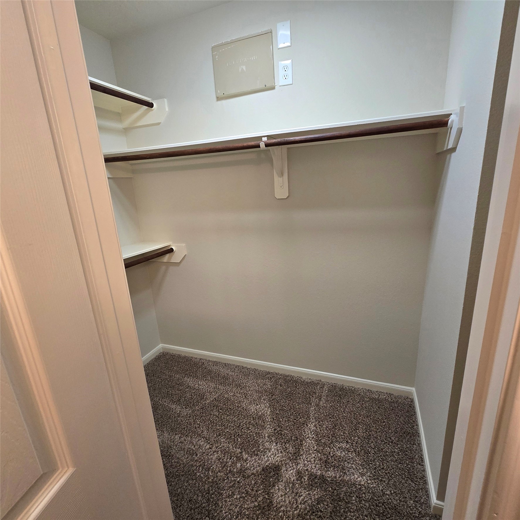 Large primary walk-in closet. Shelves and convenient rods.