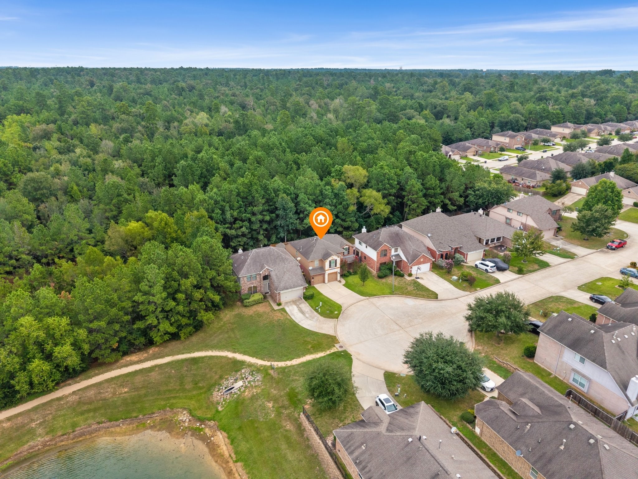 Wide aerial view illustrating the homes prime cul-de-sac location, backed directly by an expansive forest preserve and located adjacent to a peaceful community pond and walking trail.