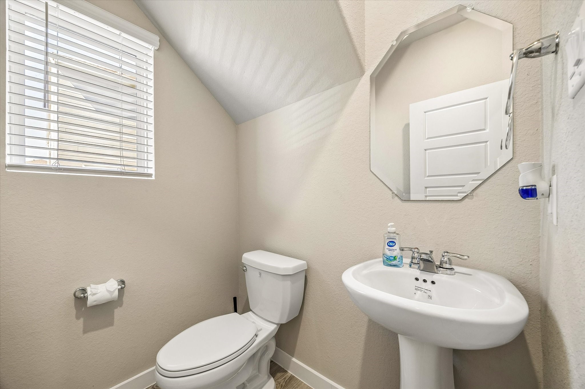 Conveniently located powder room provides an added level of functionality for guests while keeping the home's private bathrooms separate.