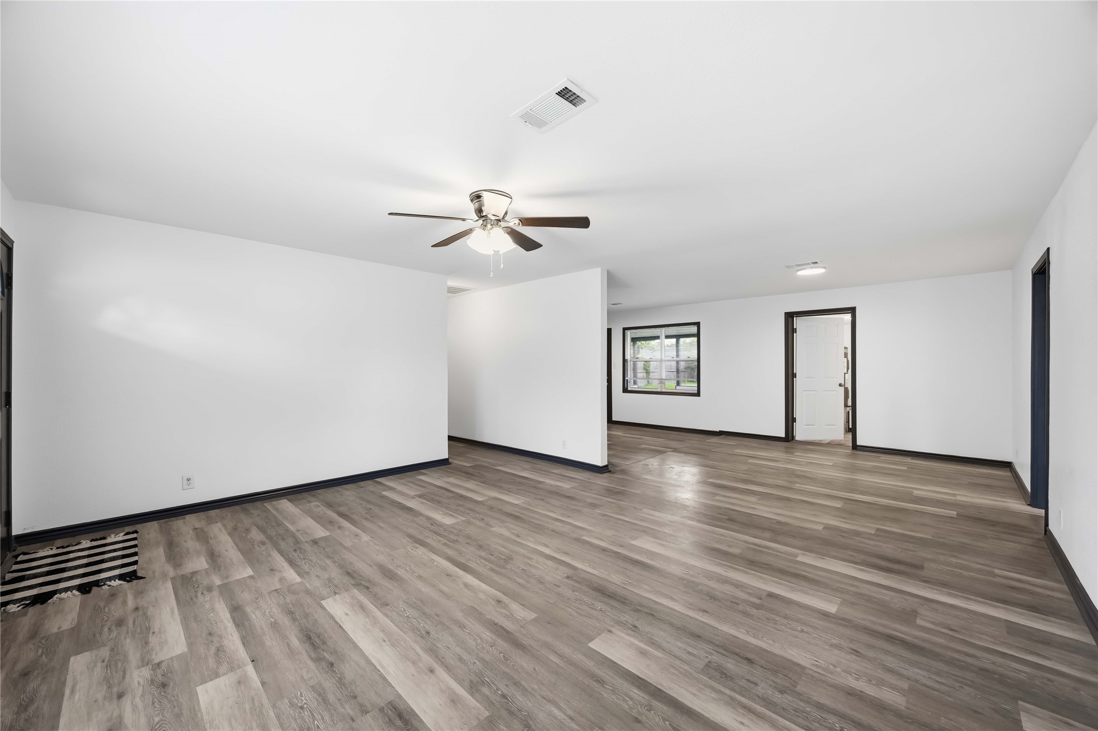 A look at the flow of this home as it seamlessly blends into the dining area and kitchen. Bedrooms to either side of this home.