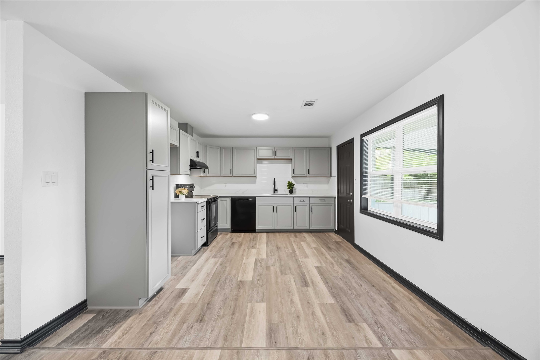 Lovely updated kitchen with plenty of storage. Black door leads to the spacious backyard.