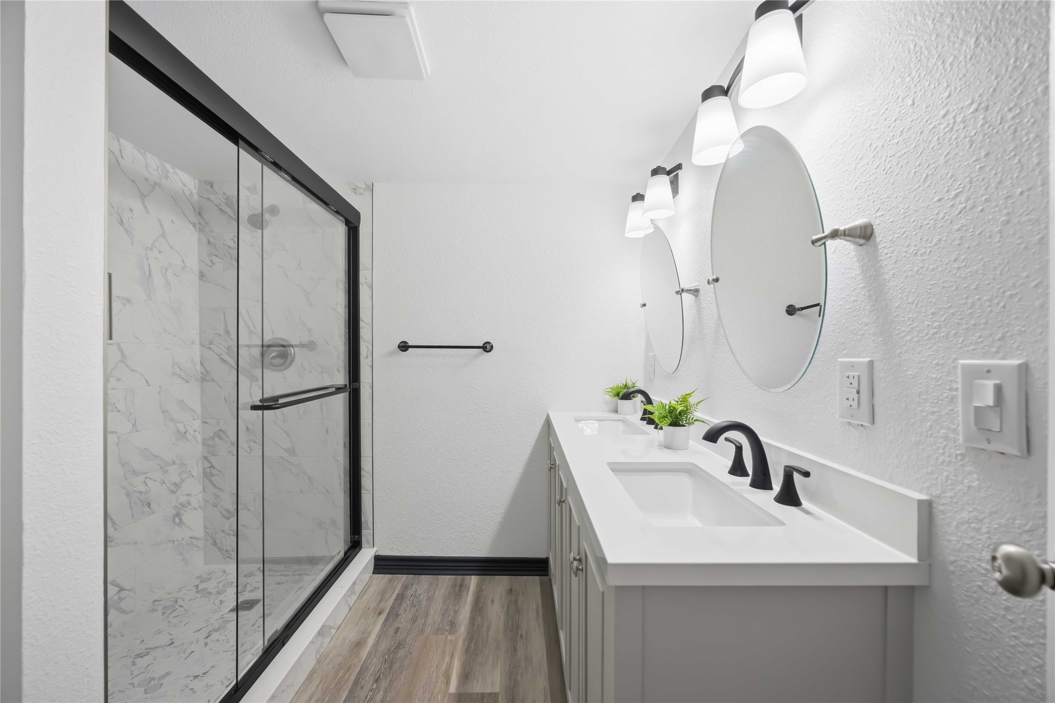 Primary bath with two sinks and vanities and a large stand-up shower.