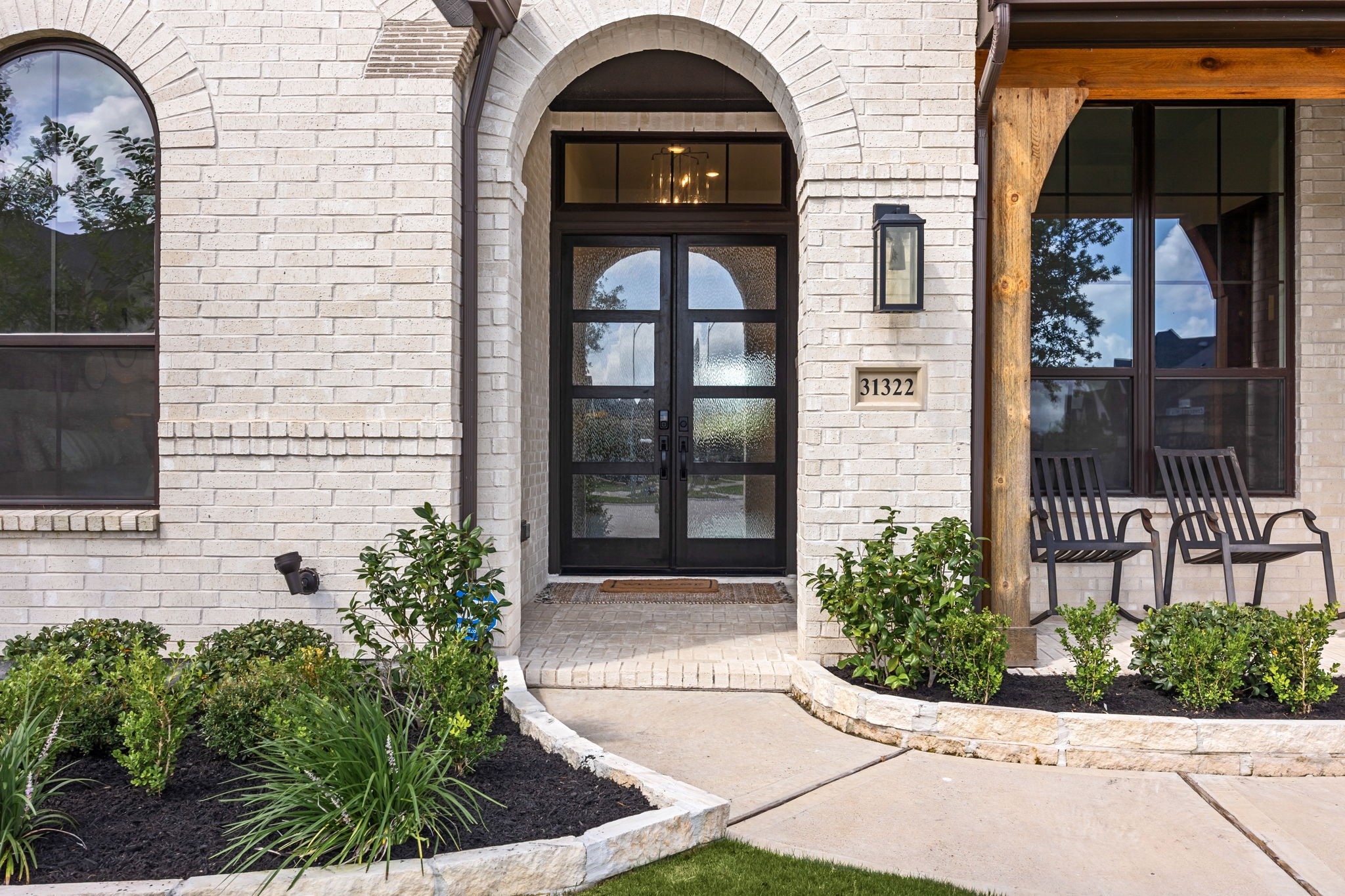 Step inside and feel right at home. This stunning arched entryway welcomes you with warm wood accents, beautiful double glass doors, and a charming front porch made for morning and evening relaxation.