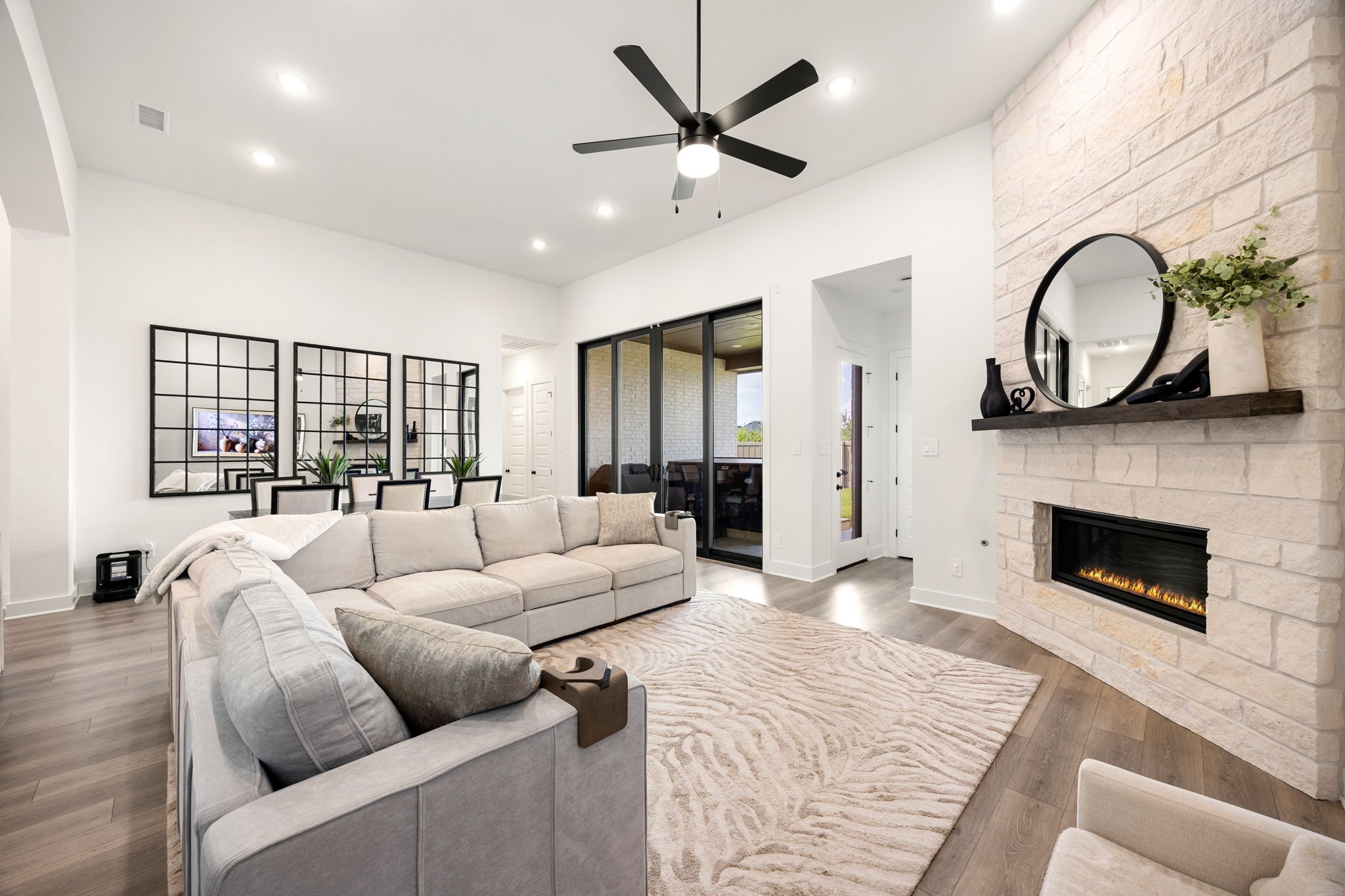 Cozy up by the fire. This expansive living space boasts a stunning floor-to-ceiling stone fireplace, soaring ceilings, and a bright, open layout perfect for gathering with loved ones.