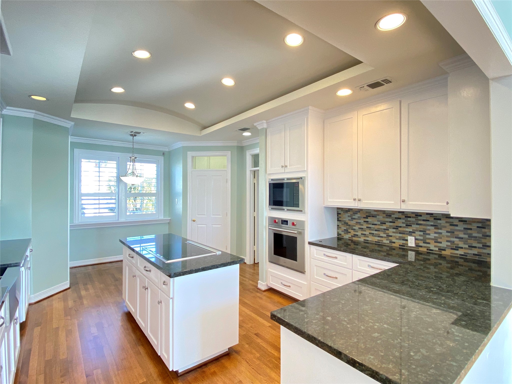 View of the kitchen with breakfast nook in the back.  Doorway leads to indoor laundry area. Large pantry on the left.