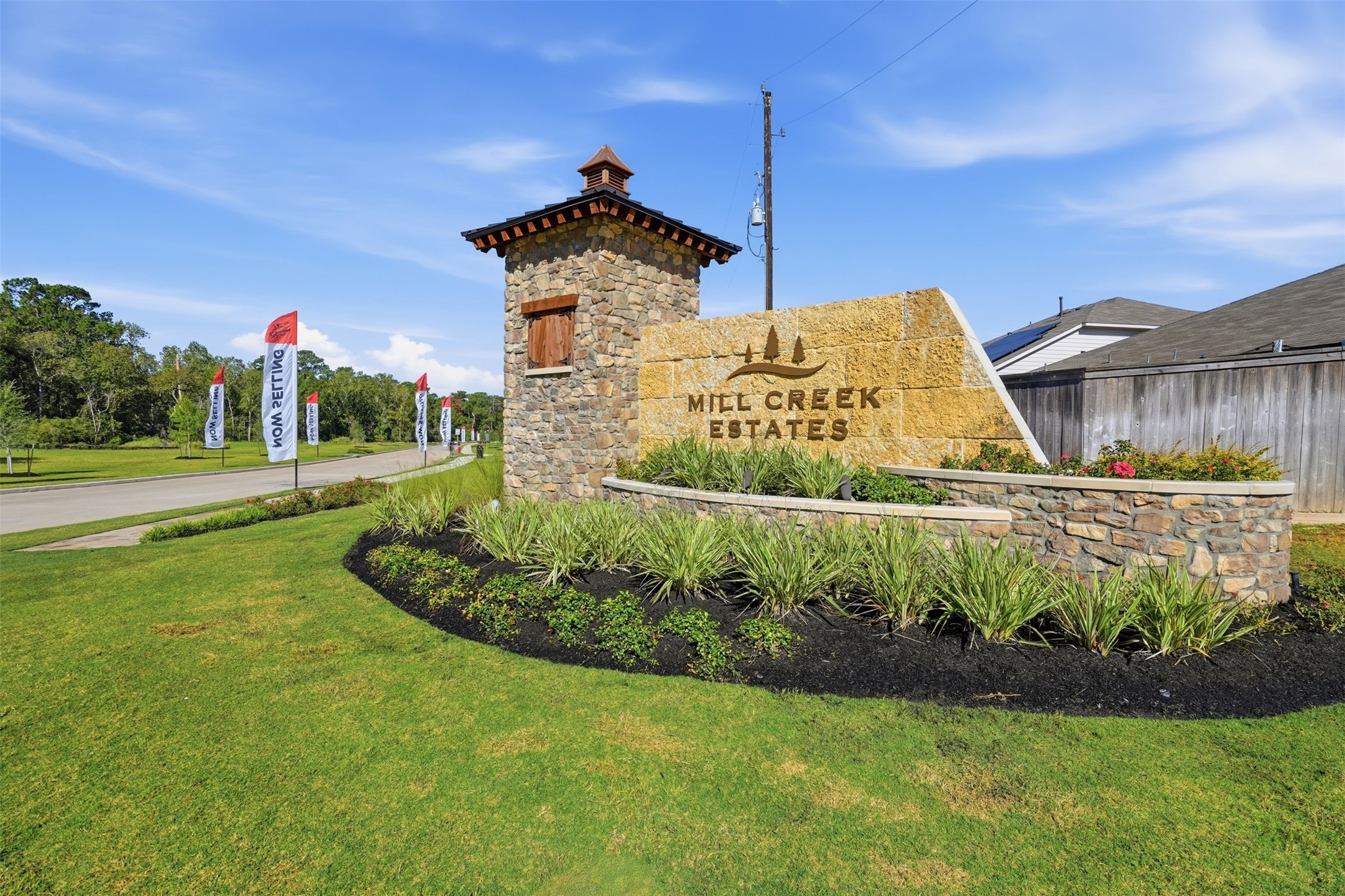 Experience the charm of Mill Creek Estates with its welcoming stone entrance, lush landscaping, and serene surroundings.