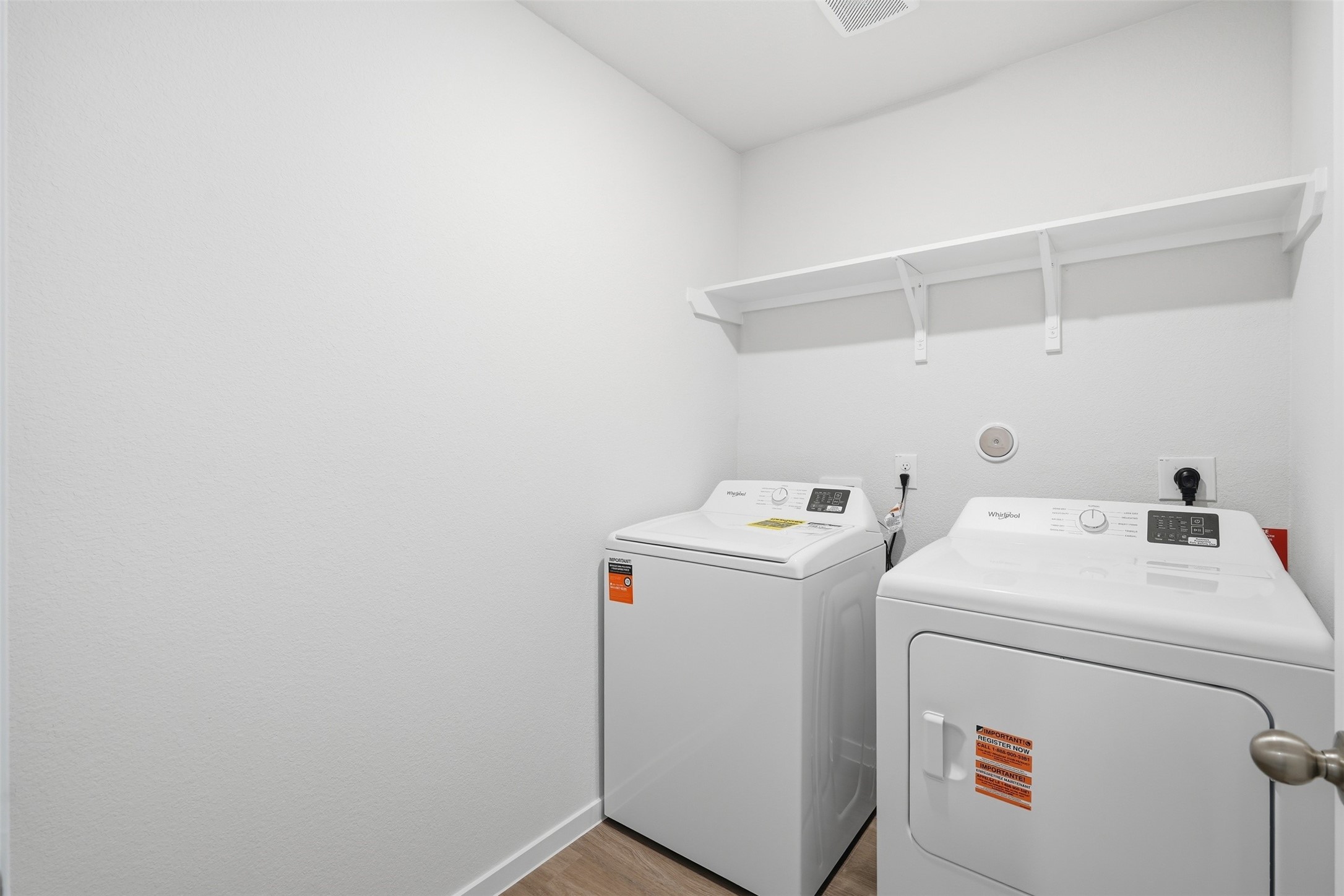 Convenient and modern laundry room equipped with a washer, dryer, and built-in shelving for extra storage.