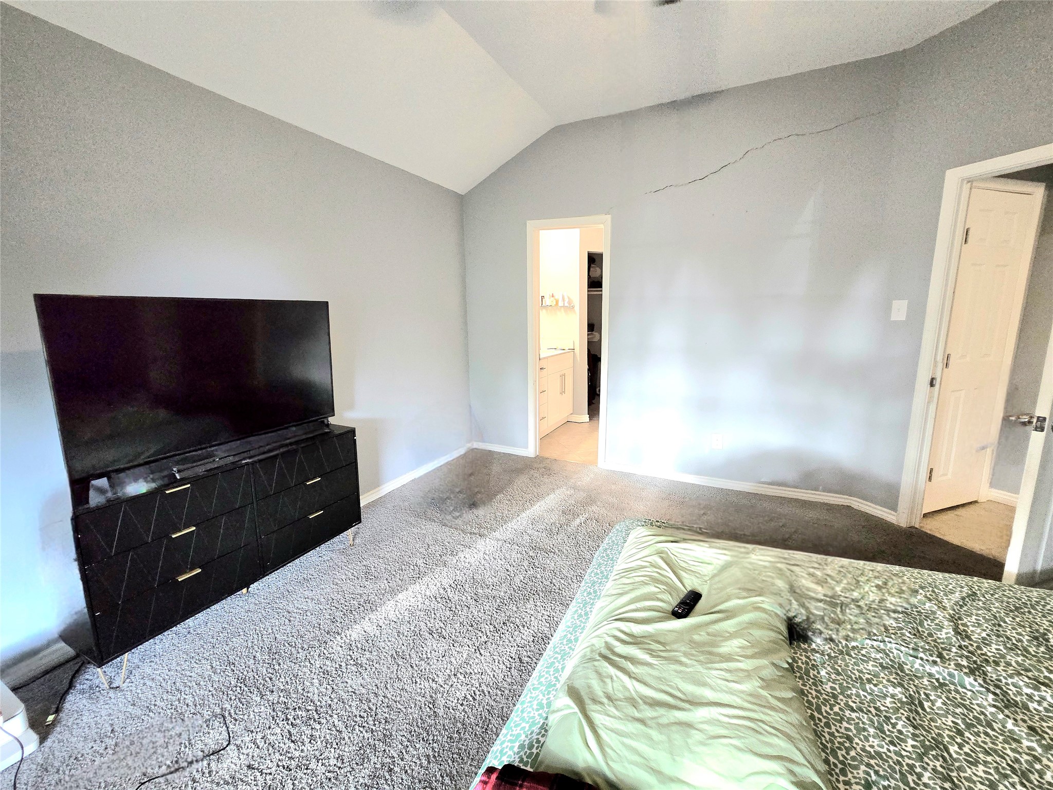 Spacious bedroom with vaulted ceilings, neutral tones, and an ensuite bathroom for added convenience.