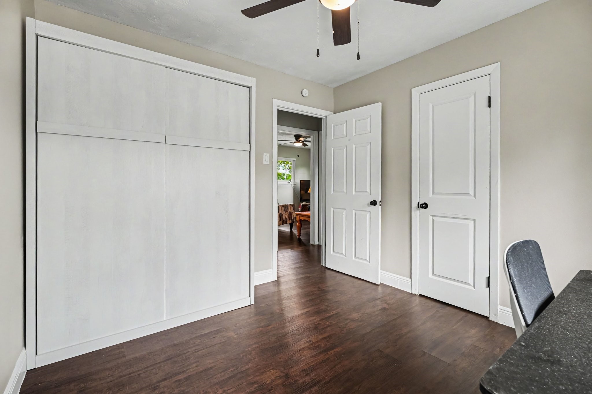 Bedroom Two with elegant laminate floors, a ceiling fan, and ample closet space, offering a cozy and functional space. Murphy Bed folds up for additional space.