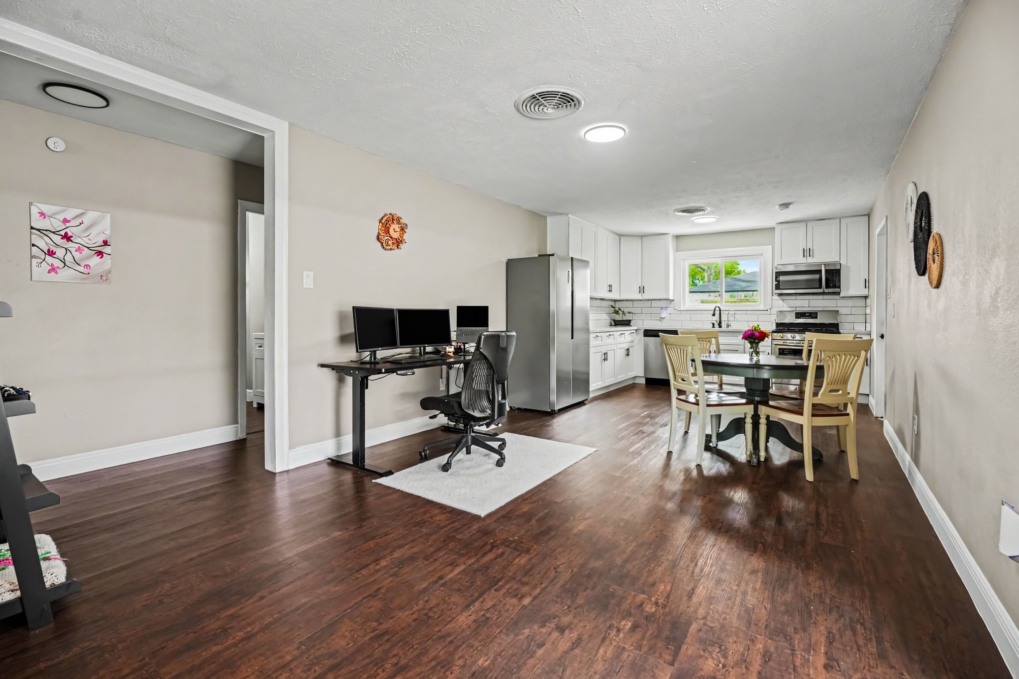 Spacious open-plan kitchen and dining area with laminate floors, modern stainless steel appliances, and ample natural light. Spacious open-plan kitchen and dining area with laminate floors, modern stainless steel appliances, and ample natural light.