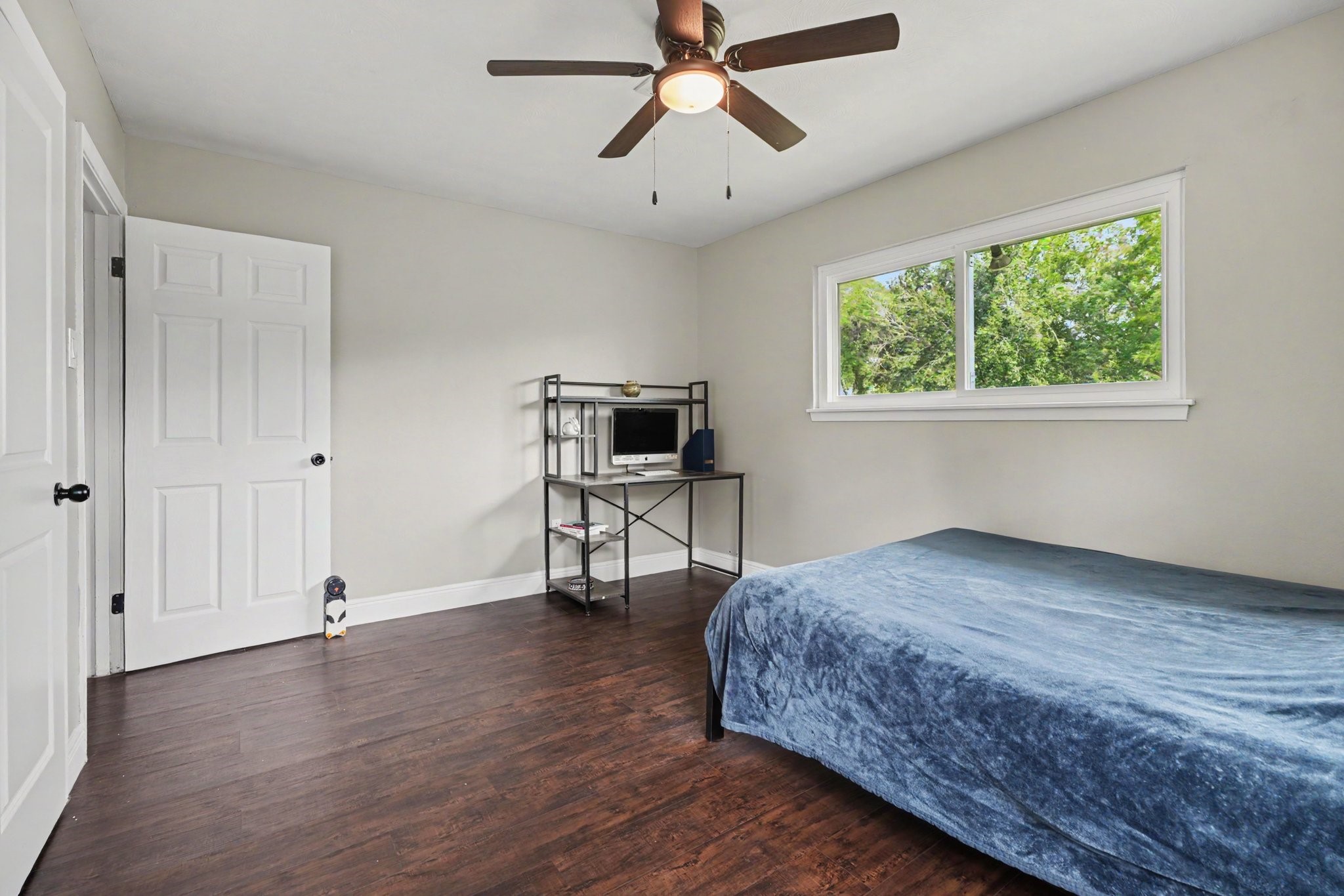 Bedroom One a large window providing natural light, and a ceiling fan for comfort.