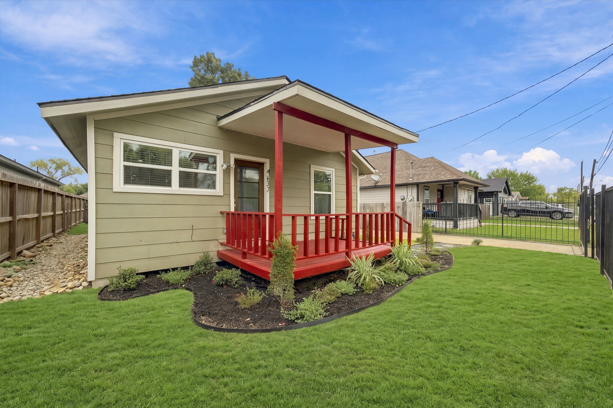 Charming bungalow with a welcoming front porch, vibrant landscaping, and a lush green lawn, perfect for enjoying outdoor relaxation.