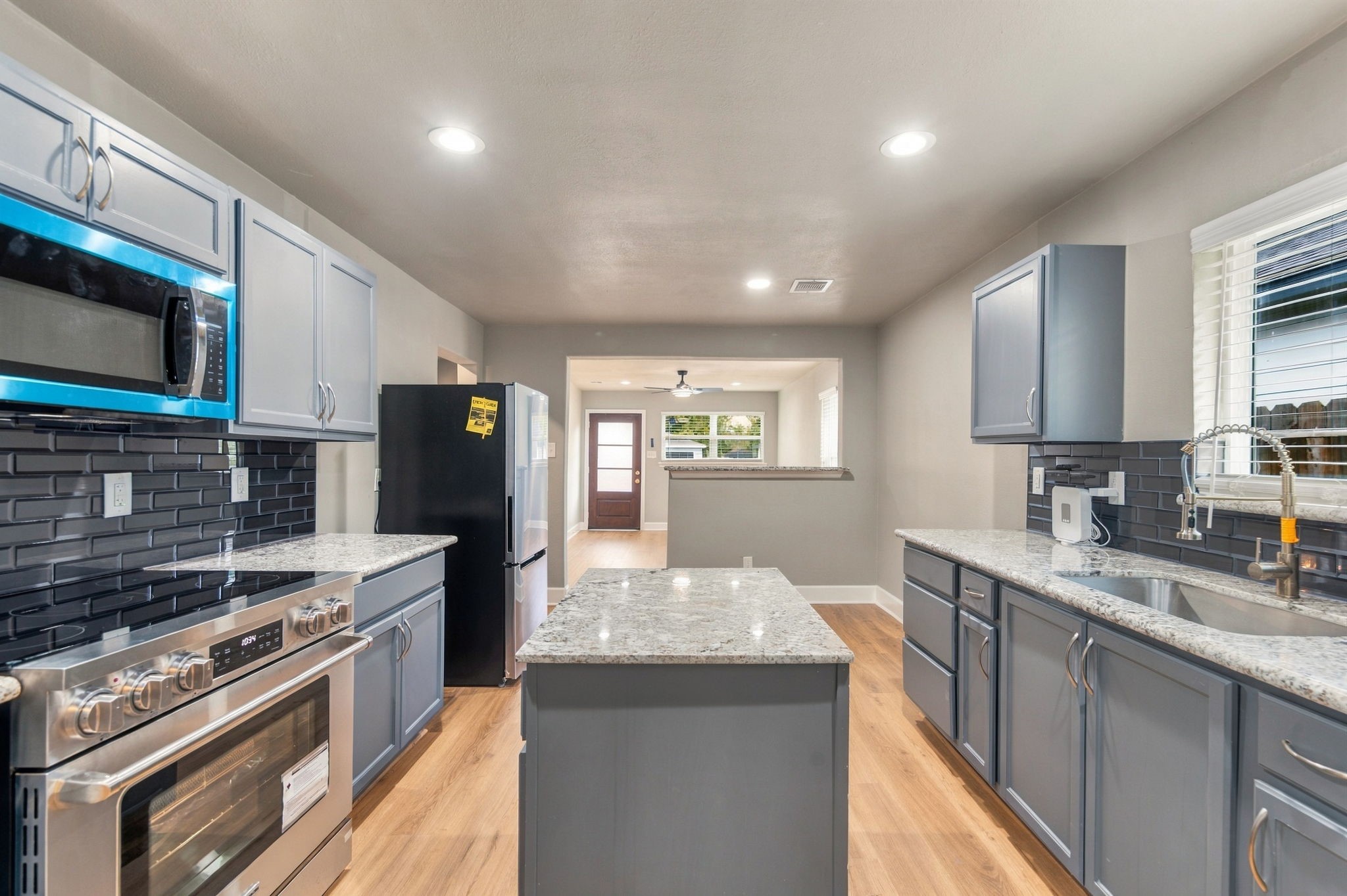 Modern kitchen with sleek stainless steel appliances, granite countertops, and stylish blue cabinetry.