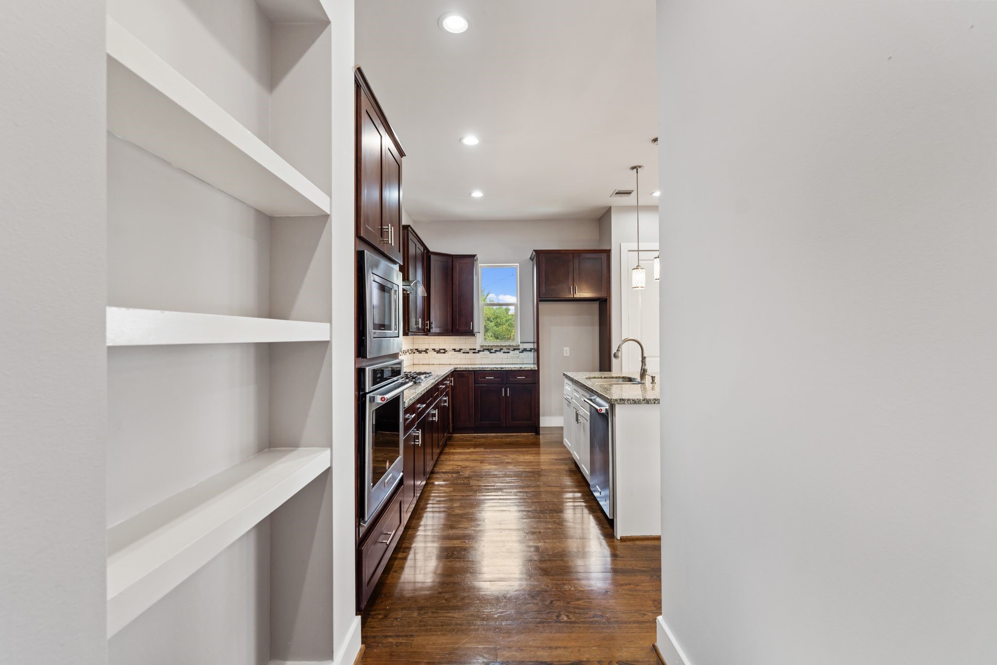 Second-floor landing leading into the kitchen and open living space, with built-in shelving.