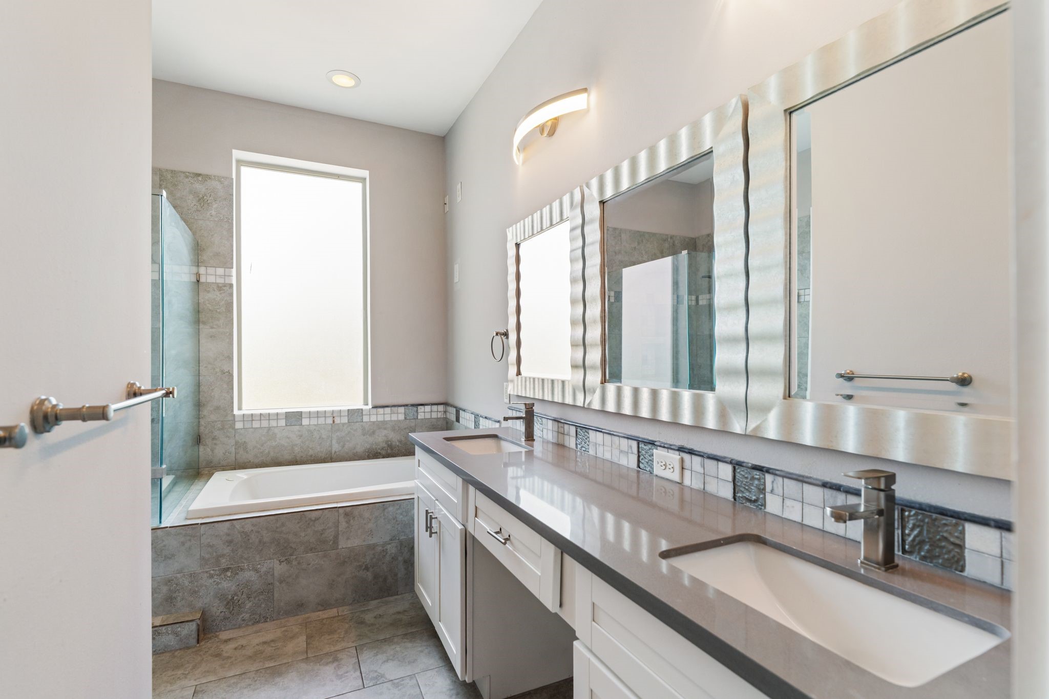 Primary bathroom featuring dual sinks and a long vanity with ample counter space.