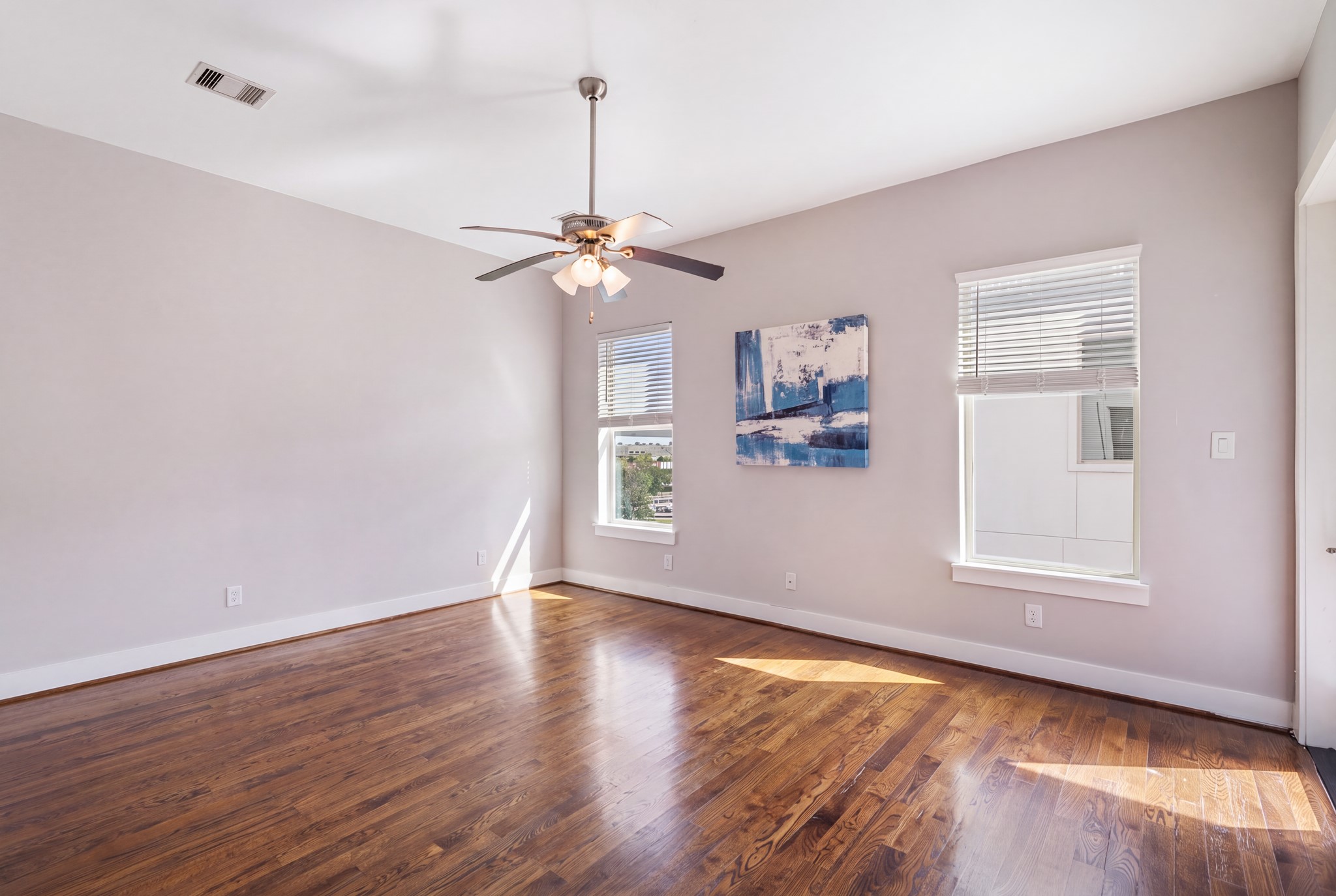Third floor primary bedroom with large windows for natural light.