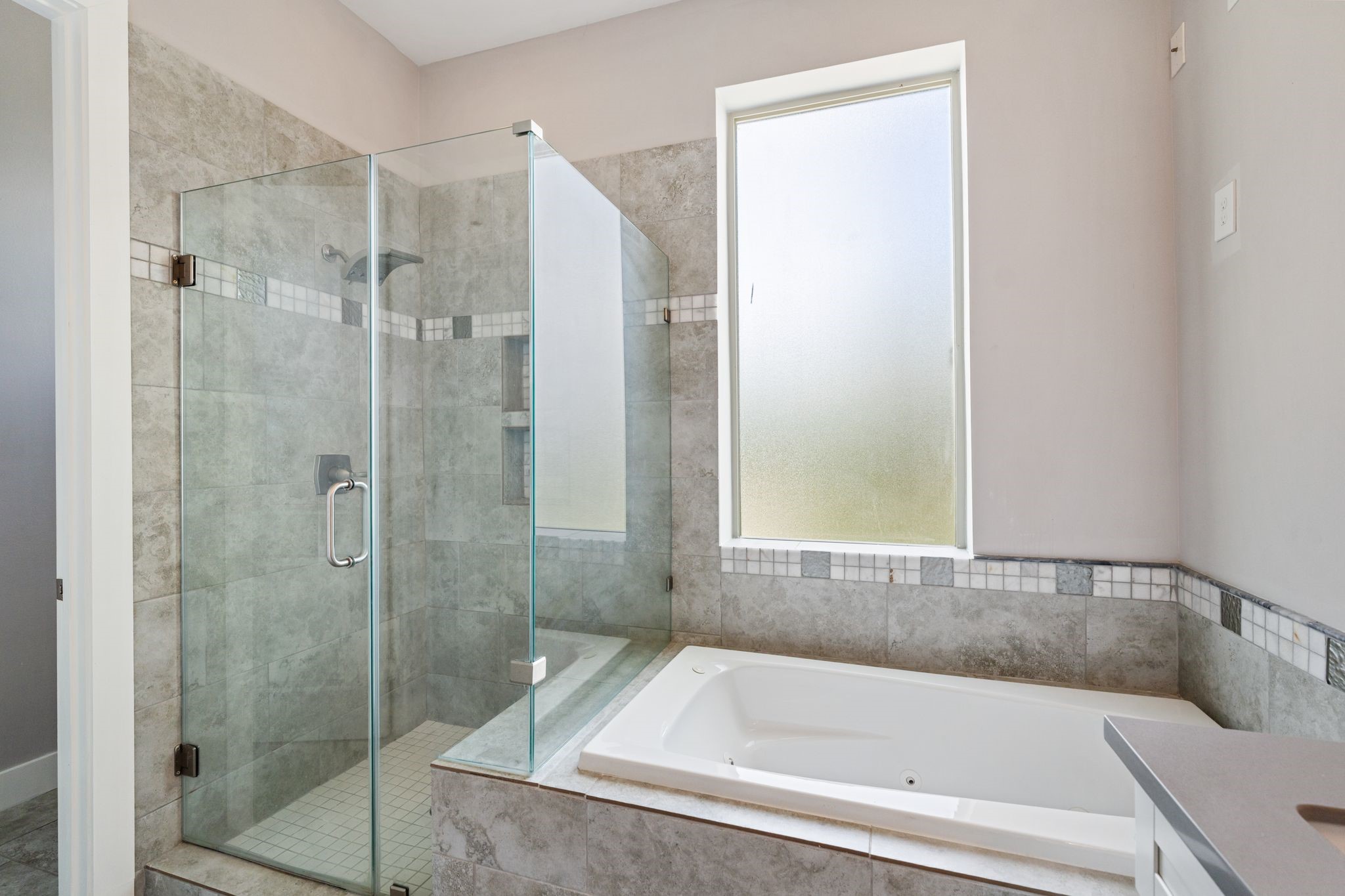 Primary bathroom soaking tub with a separate glass-enclosed shower.