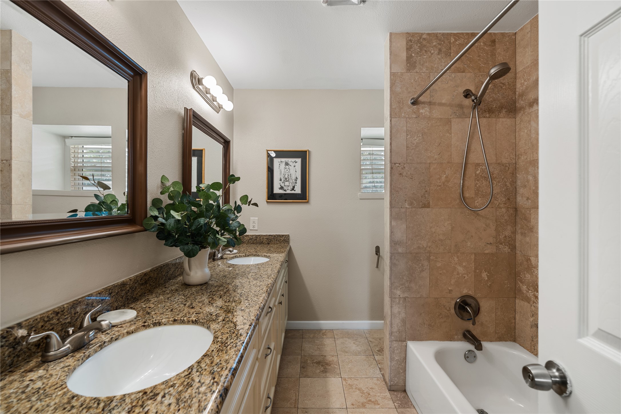 Guest bath conventiently located across from the two secondary bedrooms with double sinks, granite countertops, and a tub/shower combo.