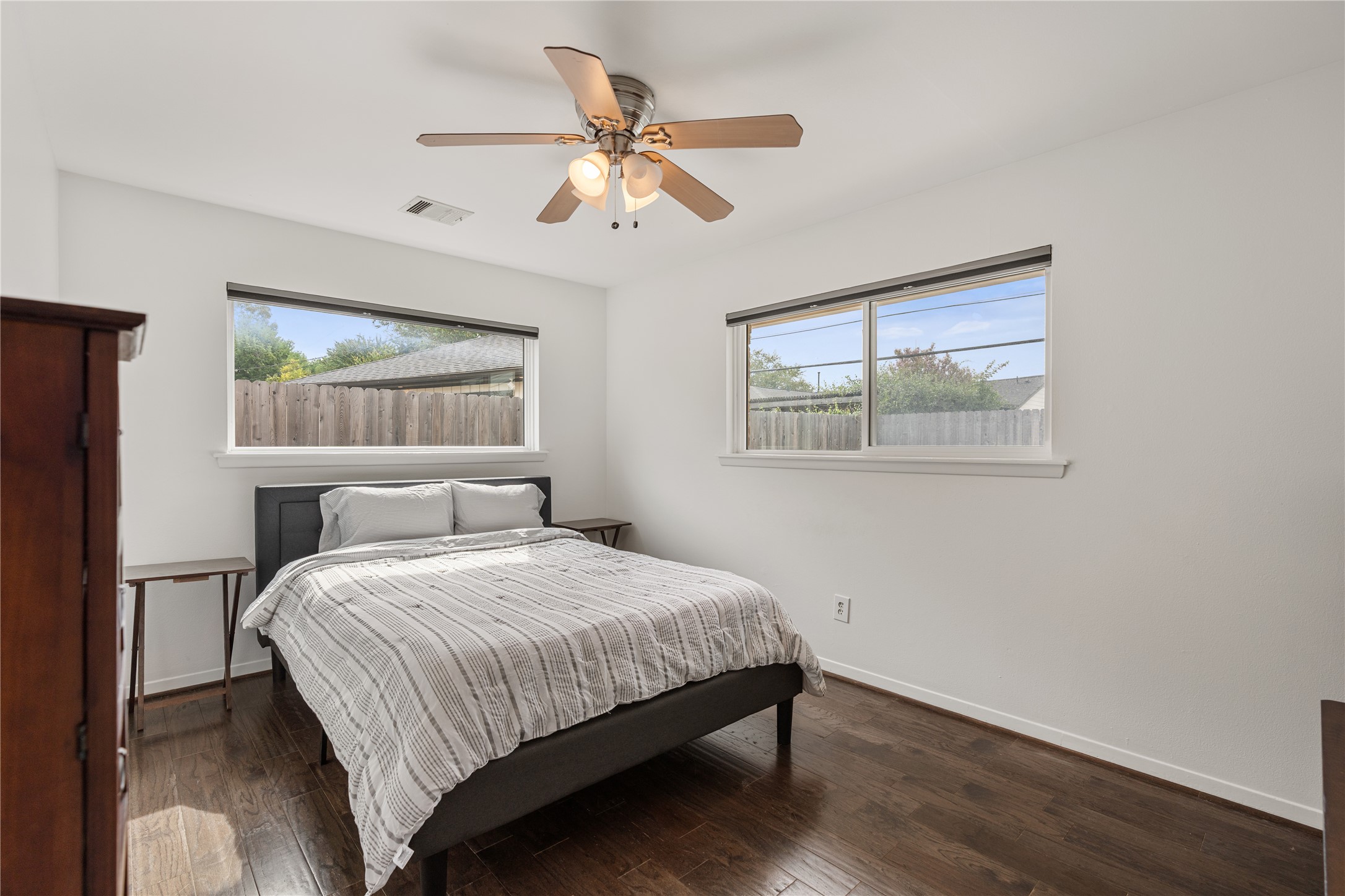Cozy secondary bedroom with abundant natural light with hardwood floors and a reach-in closet.