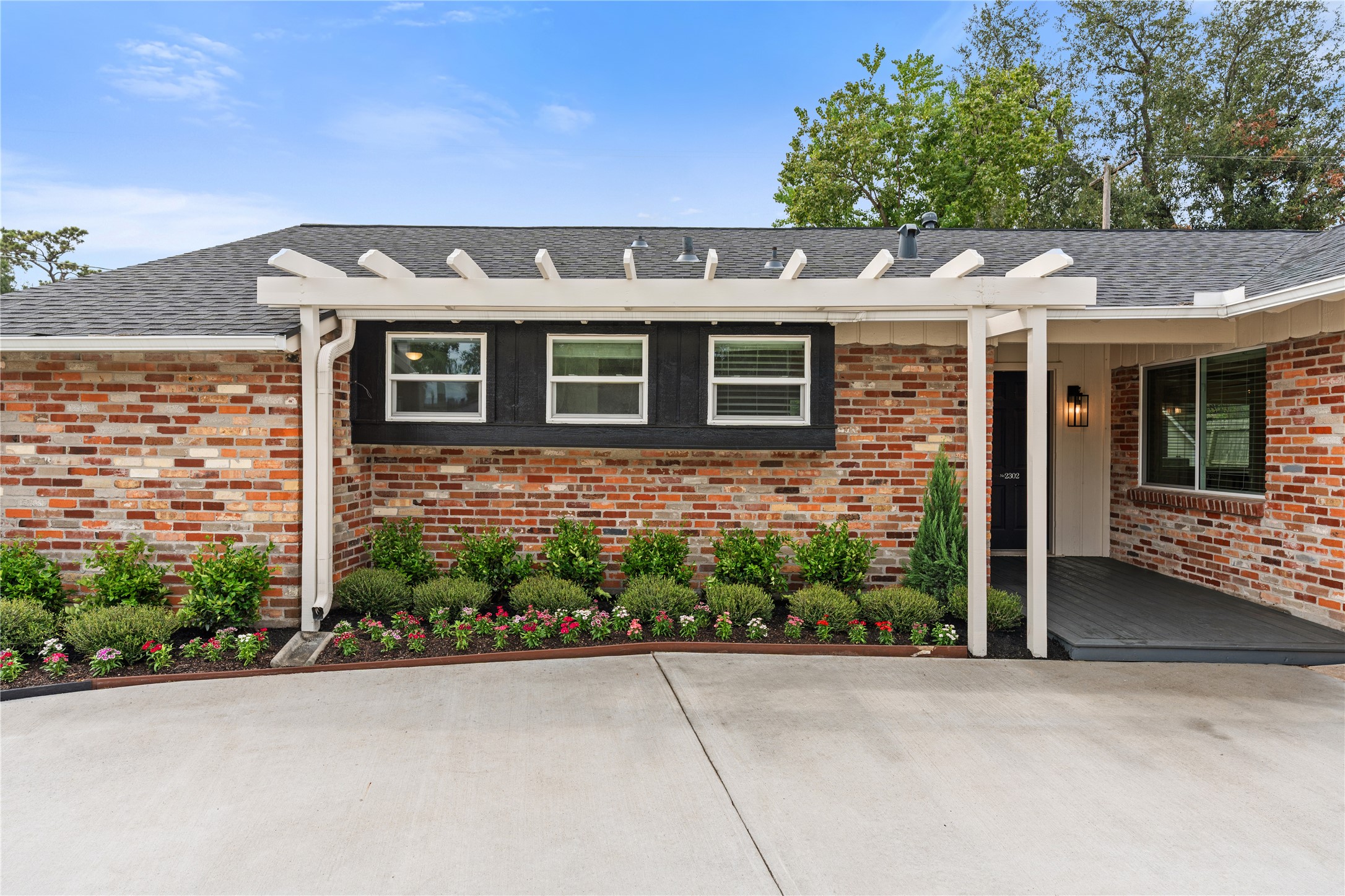 New lush landscaping under custom pergola welcomes you home New lush landscaping under custom pergola welcomes you home