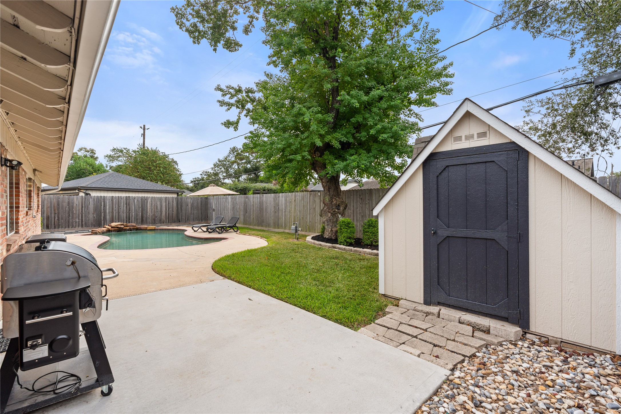 Designed for more than just pool days, the backyard offers green space, a patio for grilling + entertaining, and a storage shed for all the extras.