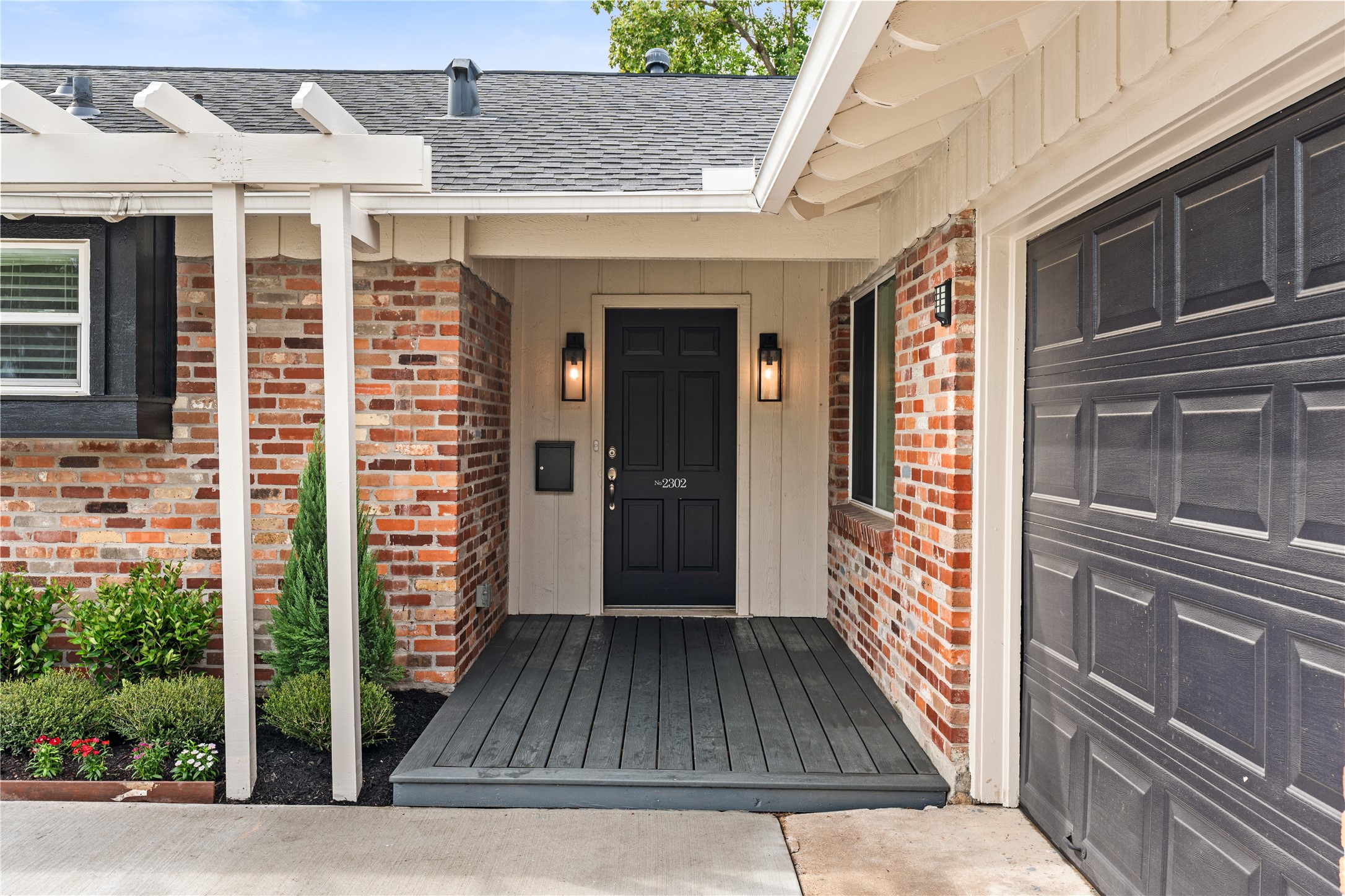 Charming entryway with a classic black door, flanked by stylish lanterns and set against a warm brick facade, offering a welcoming first impression. Charming entryway with a classic black door, flanked by stylish lanterns and set against a warm brick facade, offering a welcoming first impression.
