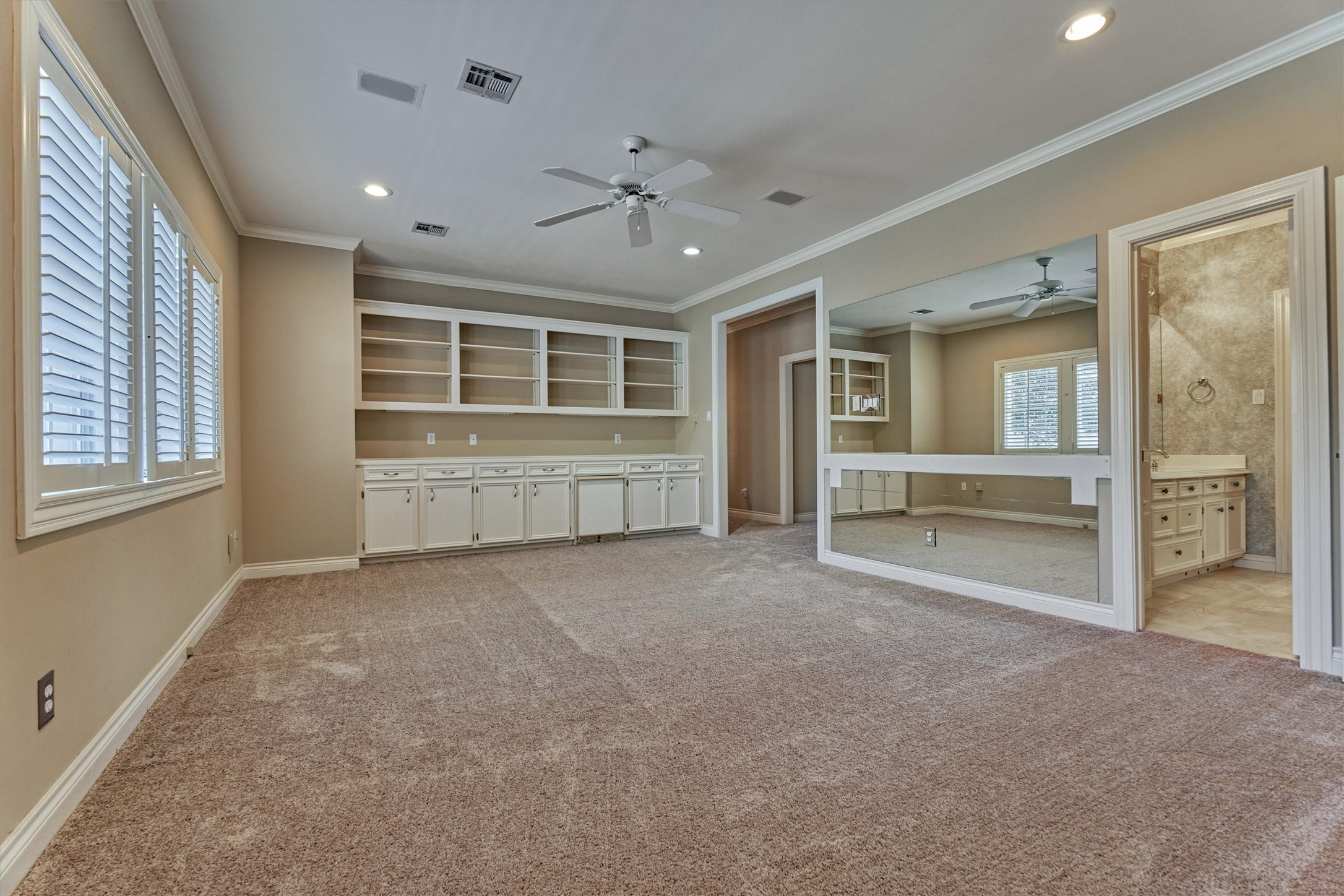 Another angle of this big game room shows how much space there is for game nights, movie marathons, or a teen hangout. Built-in shelves and cabinets keep everything organized, and the counter is a handy snack and drink station. The Jack and Jill bath is right next door, and a second staircase leads straight down to the family room, so its easy to move between floors.