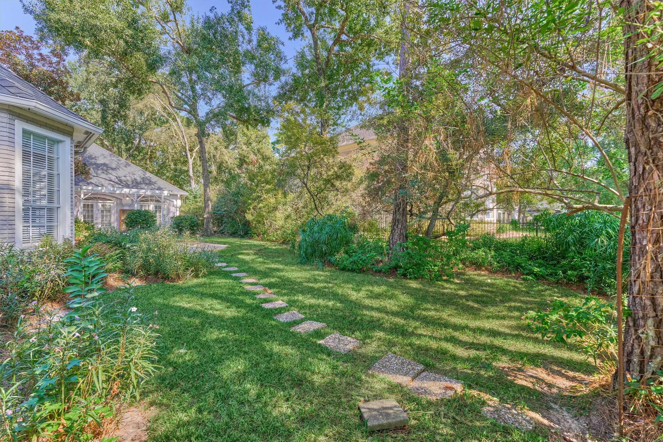 Picture a pool, a play area, or a garden in this spacious backyard, which has plenty of room to build the outdoor space you want. Tall trees give it shade and privacy, and a stepping-stone path winds from the patio across the lawn. The inground spa and covered patio are already in place, so you can start entertaining right away.