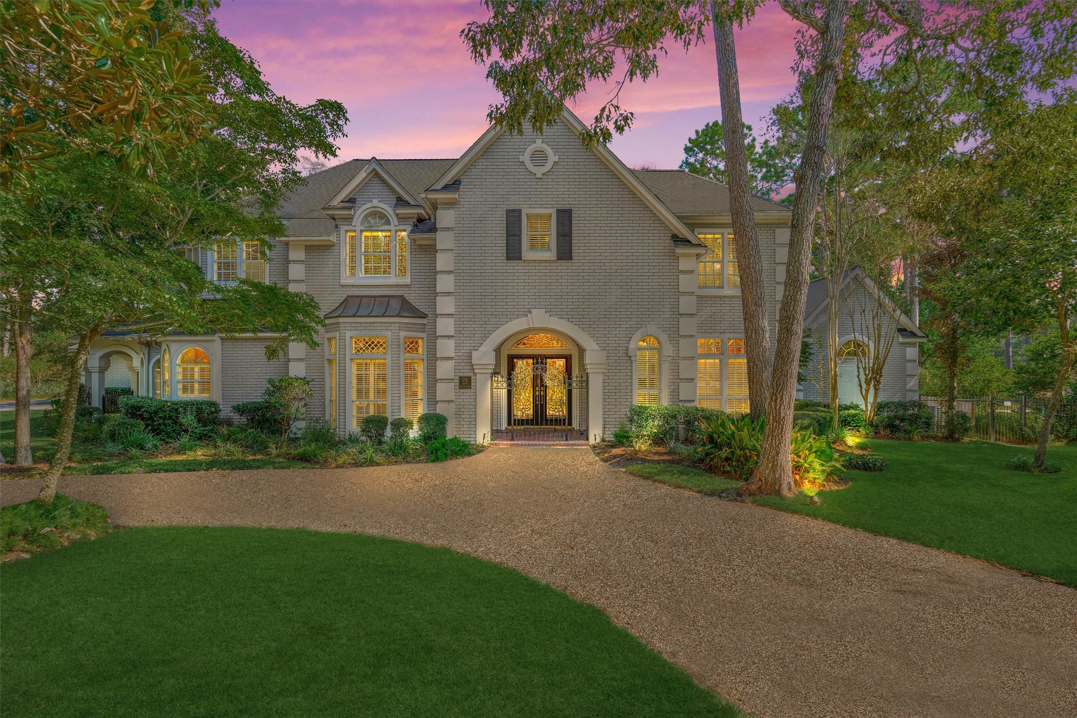 Welcome to 26 S Brokenfern. A circular driveway leads to this elegant brick and stucco home, framed by mature magnolia and oak trees. Arched details, an iron-and-glass entry, and lush landscaping give it timeless curb appeal. Welcome to 26 S Brokenfern. A circular driveway leads to this elegant brick and stucco home, framed by mature magnolia and oak trees. Arched details, an iron-and-glass entry, and lush landscaping give it timeless curb appeal.