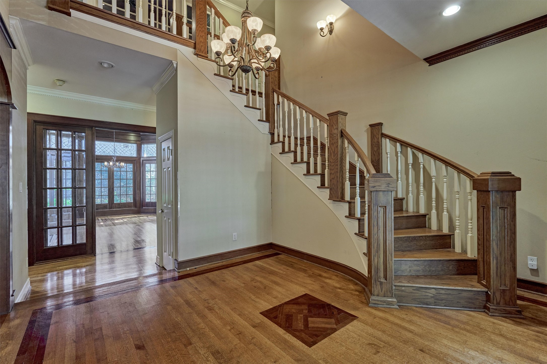 Make a grand first impression in this soaring foyer with its curved staircase, hardwood floors, and gracious chandelier. The open sightline through French doors leads to the library beyond, creating a seamless flow for entertaining and everyday living. A second-floor balcony overlooks the entry, adding to the sense of openness.