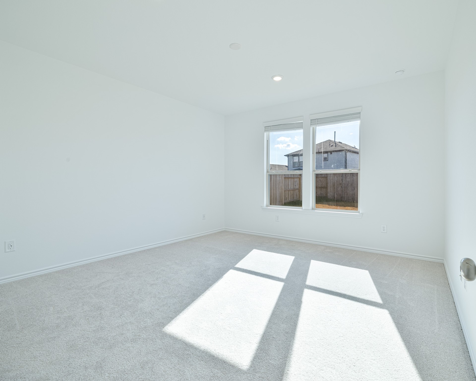 Spacious primary suite with natural light and peaceful backyard view