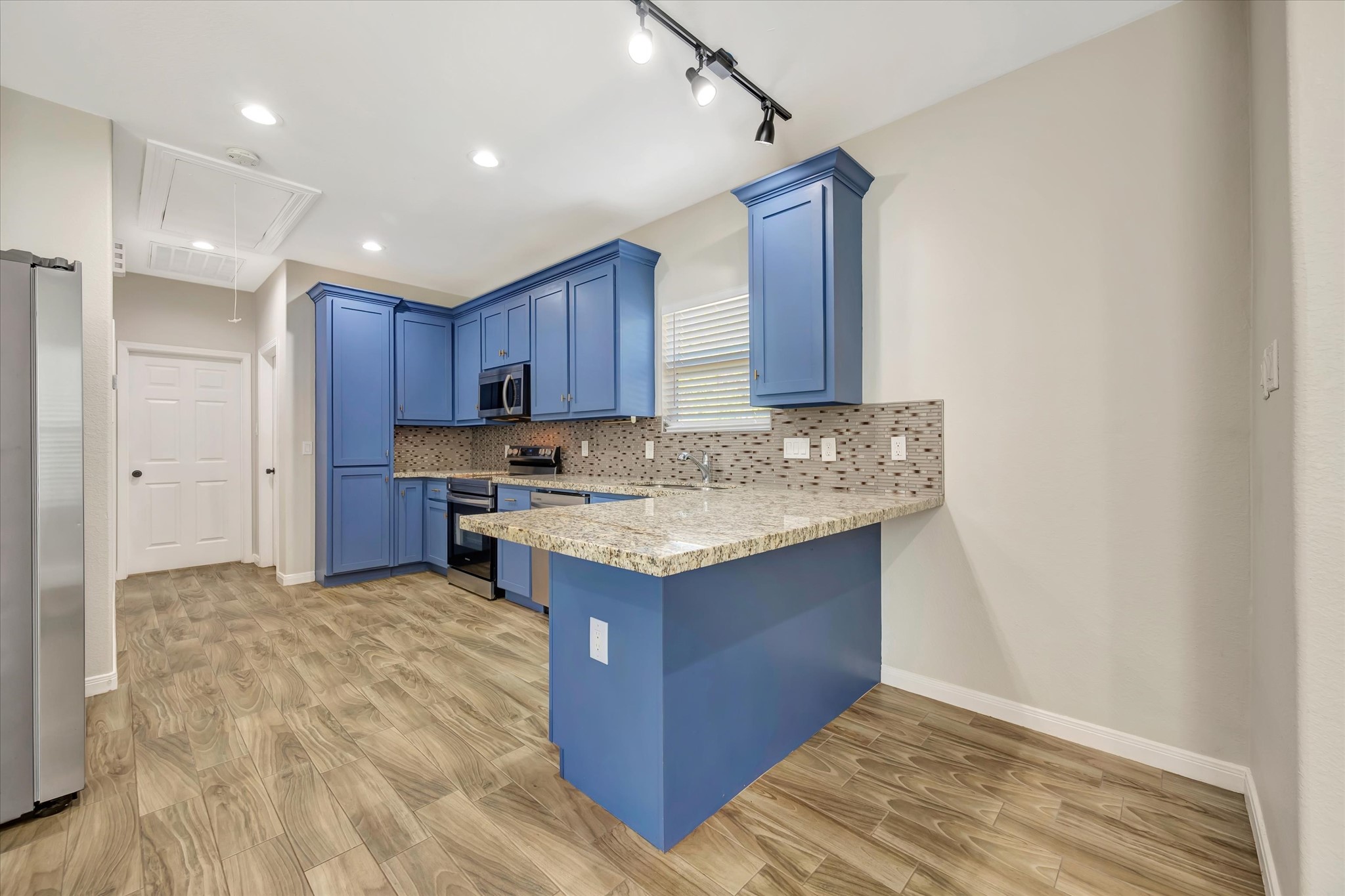 Kitchen with bar area and track lighting Kitchen with bar area and track lighting
