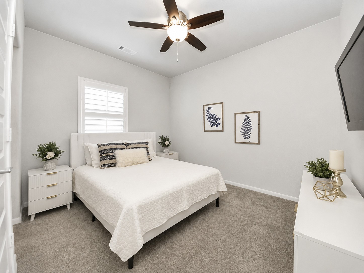 This inviting upstairs secondary bedroom features a ceiling fan, walk-in closet, ample natural light flowing through window, and adjoining secondary bath.