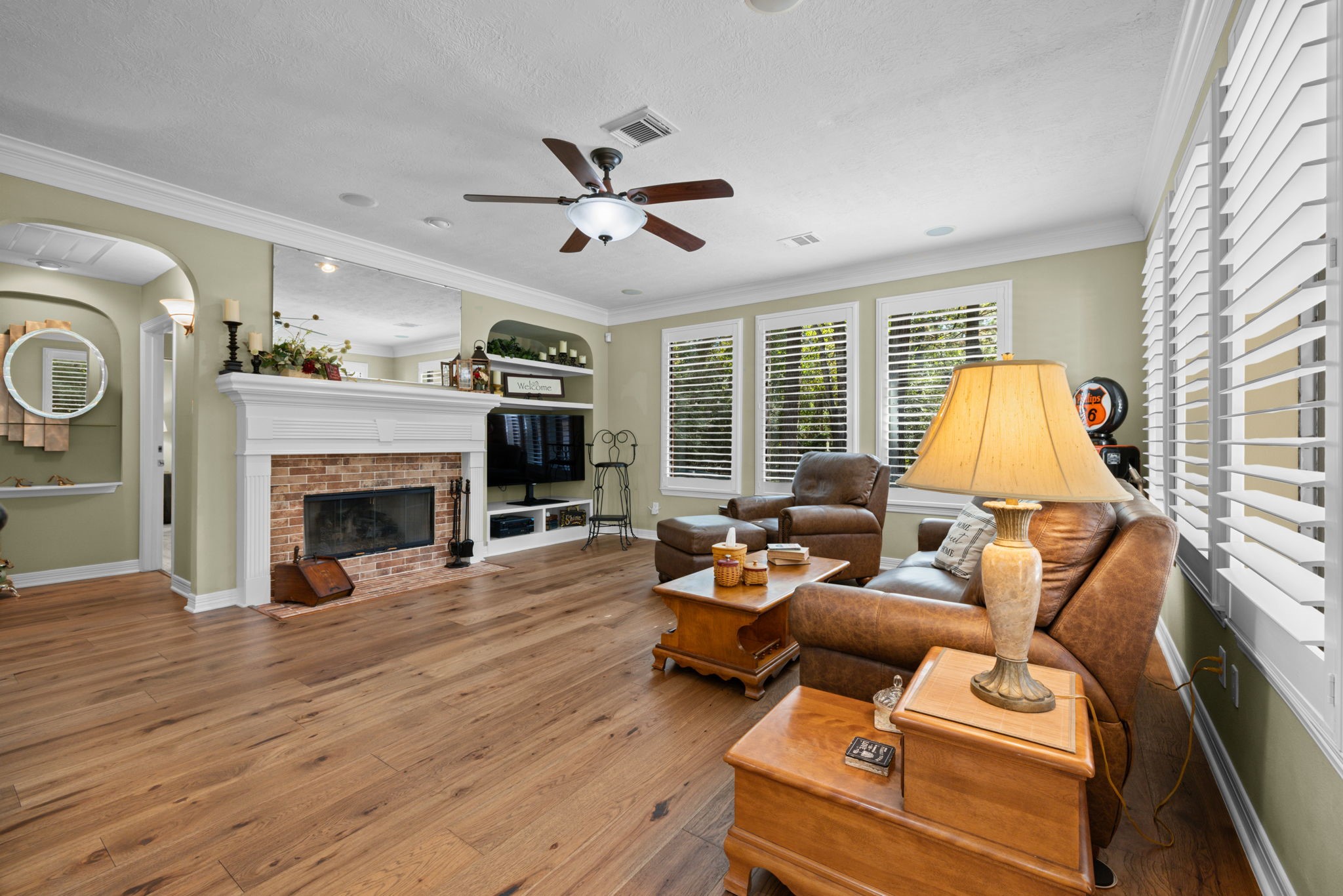 Family room features cozy fireplace, surround sound and plantation shutters
