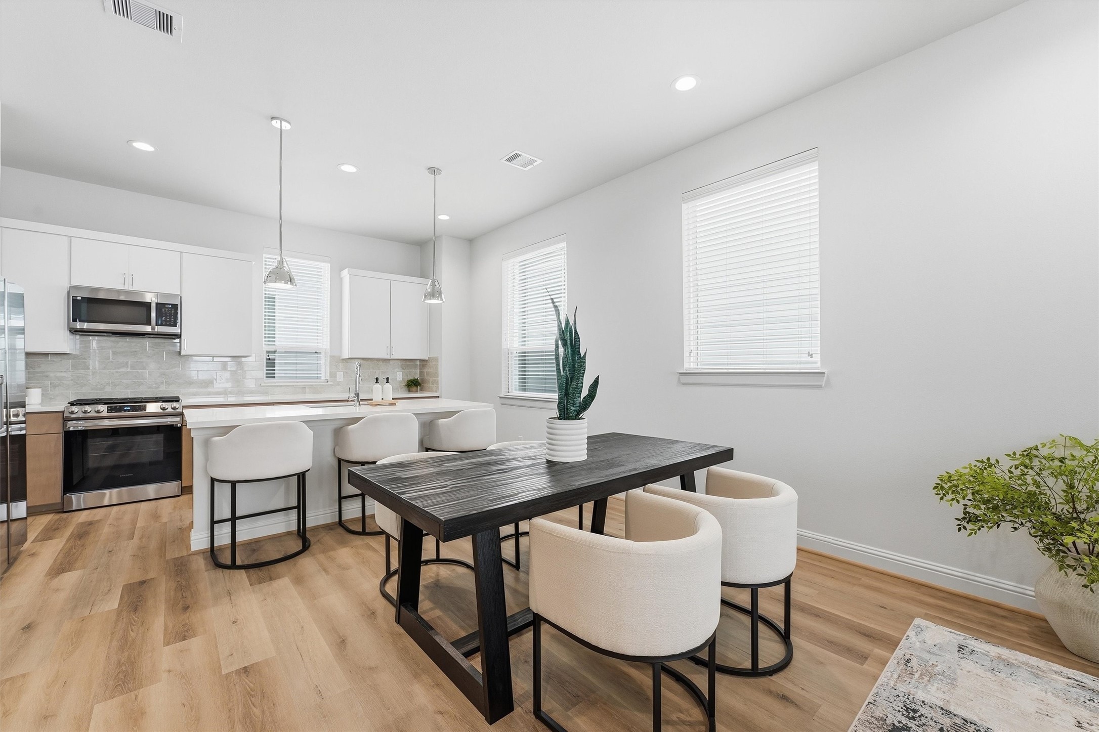 Discover seamless elegance in this open-concept space, where a modern kitchen with sleek finishes flows effortlessly into a cozy dining area perfect for entertaining. Discover seamless elegance in this open-concept space, where a modern kitchen with sleek finishes flows effortlessly into a cozy dining area perfect for entertaining.
