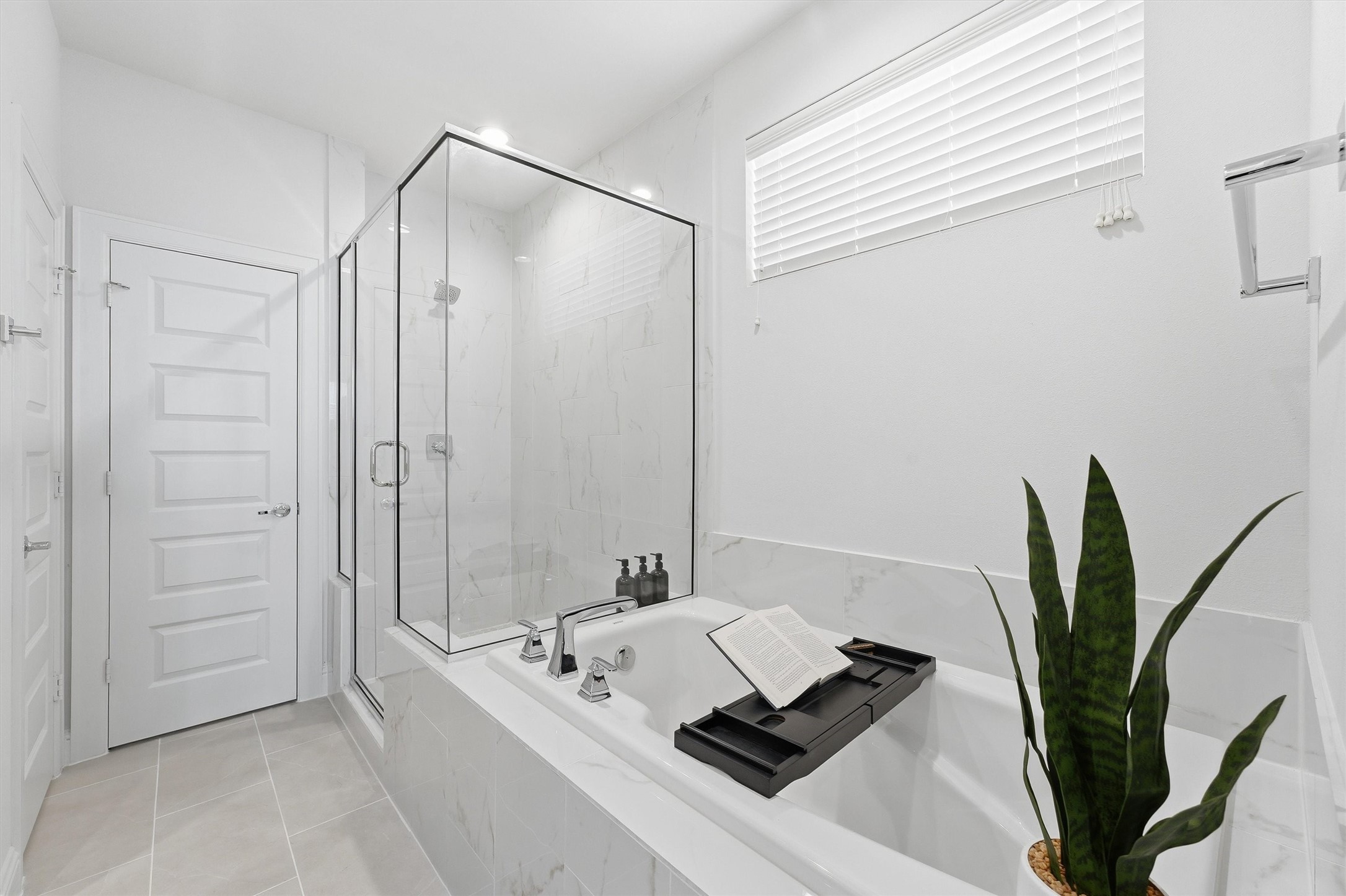 Indulge in a serene retreat with a luxurious soaking tub and sleek glass-enclosed shower, perfect for unwinding in style.