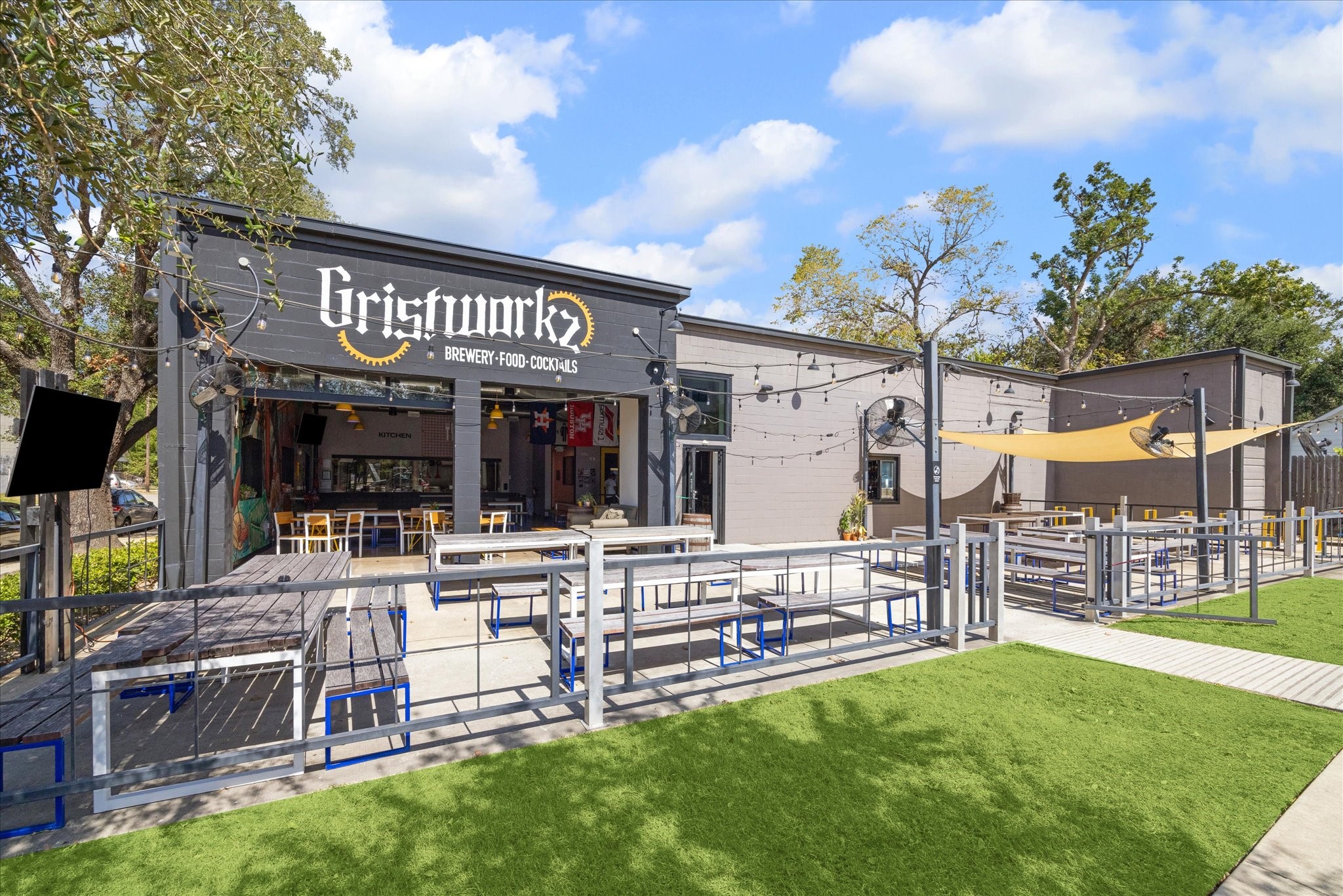 Charming brewery with a spacious outdoor seating area, featuring string lights and a cozy atmosphere perfect for social gatherings.