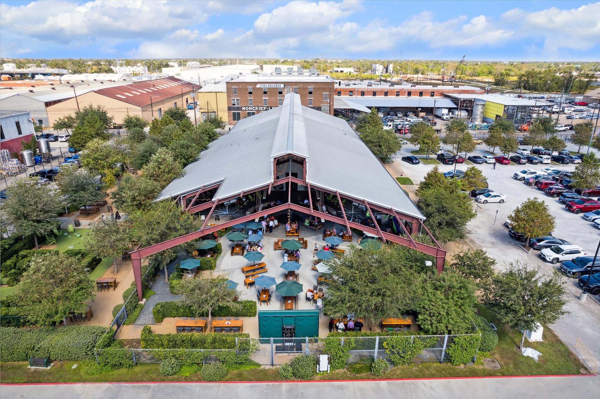 Explore a vibrant community hub with ample outdoor seating, lush greenery, and a spacious pavilion, perfect for gatherings and relaxation.