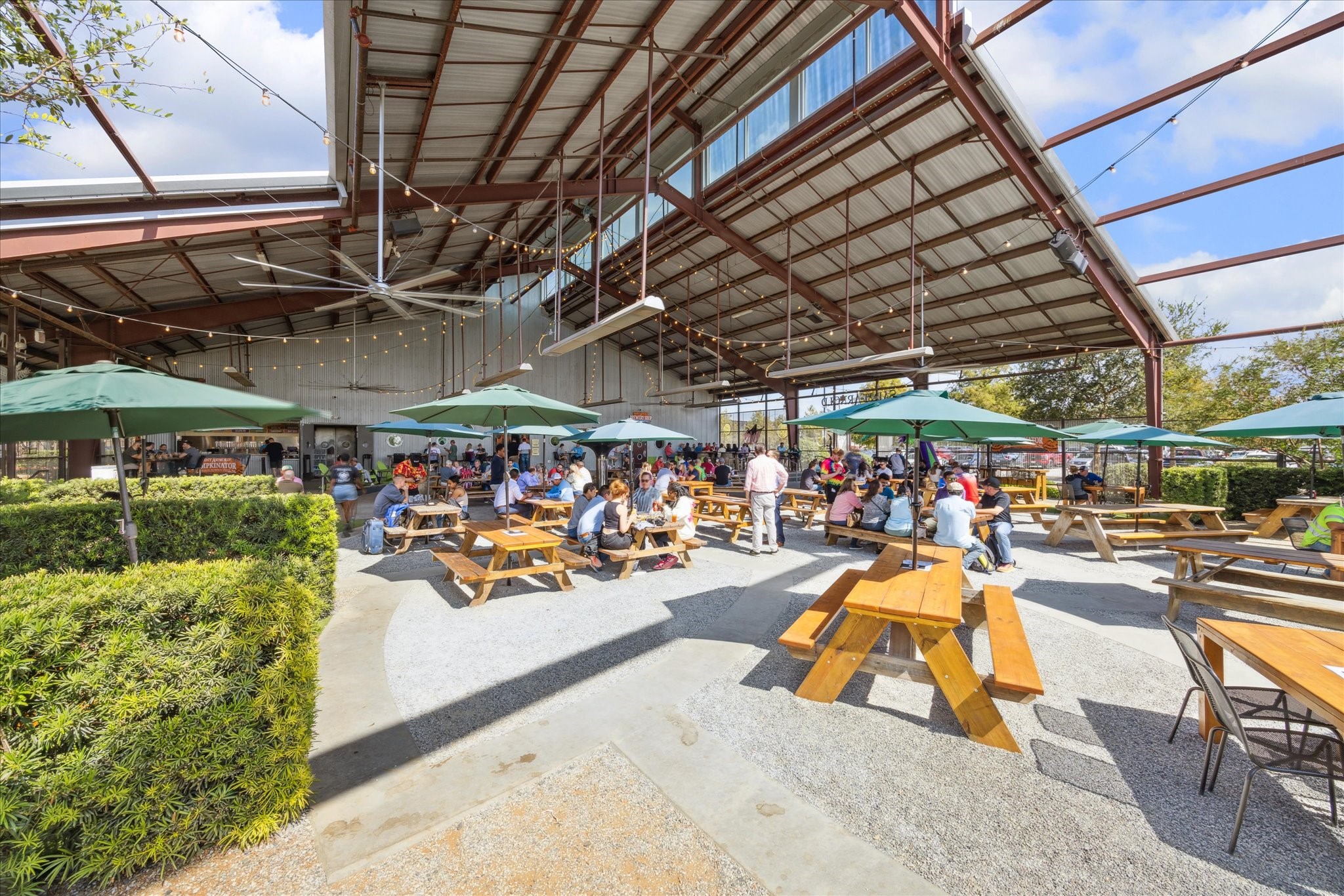 Spacious outdoor seating area with picnic tables and umbrellas nearby, perfect for gatherings and enjoying sunny days.