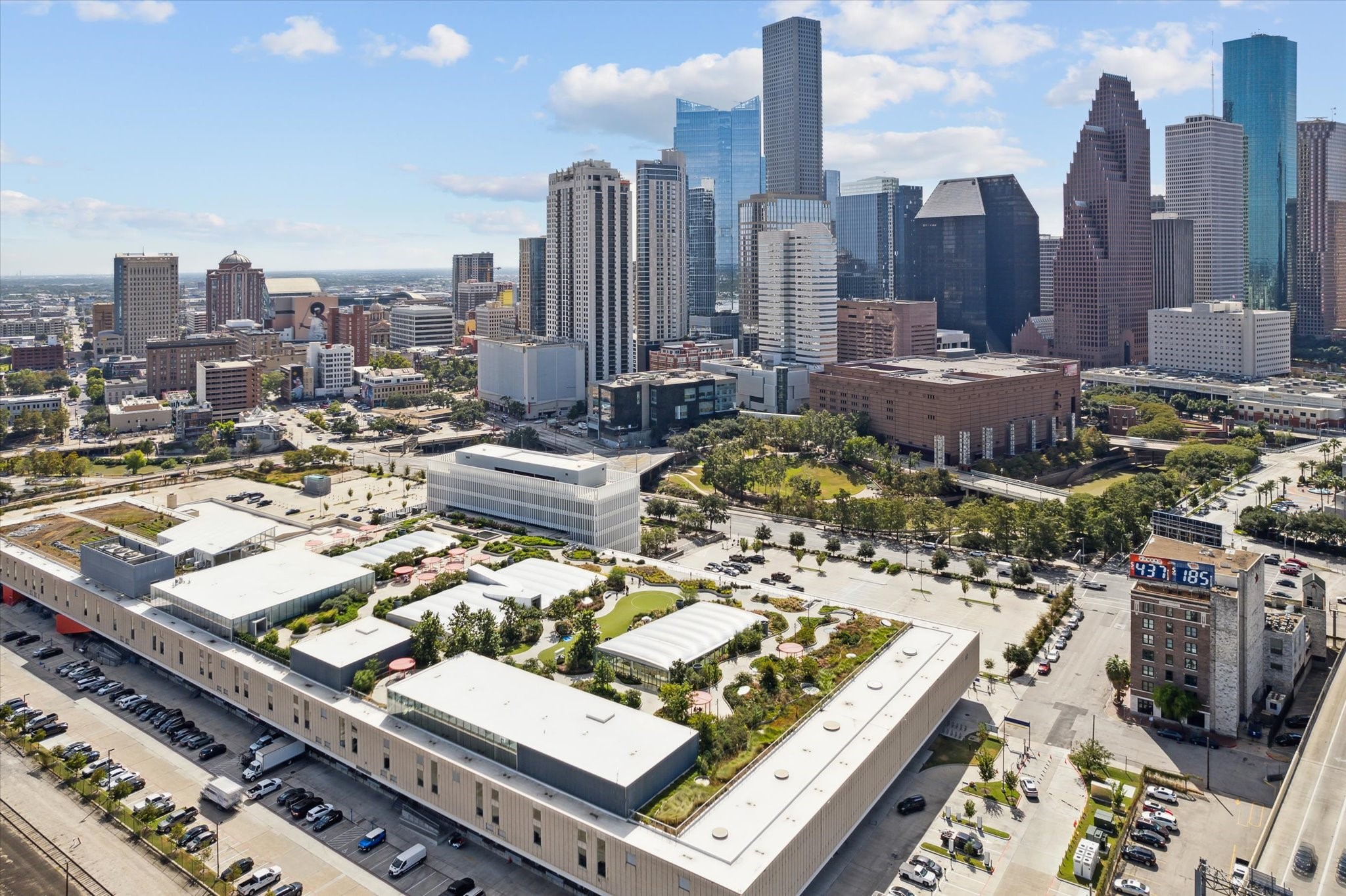 Experience vibrant city living with this stunning urban view showcasing the downtown skyline, surrounded by modern architecture and lush green spaces, perfect for those seeking a dynamic lifestyle.