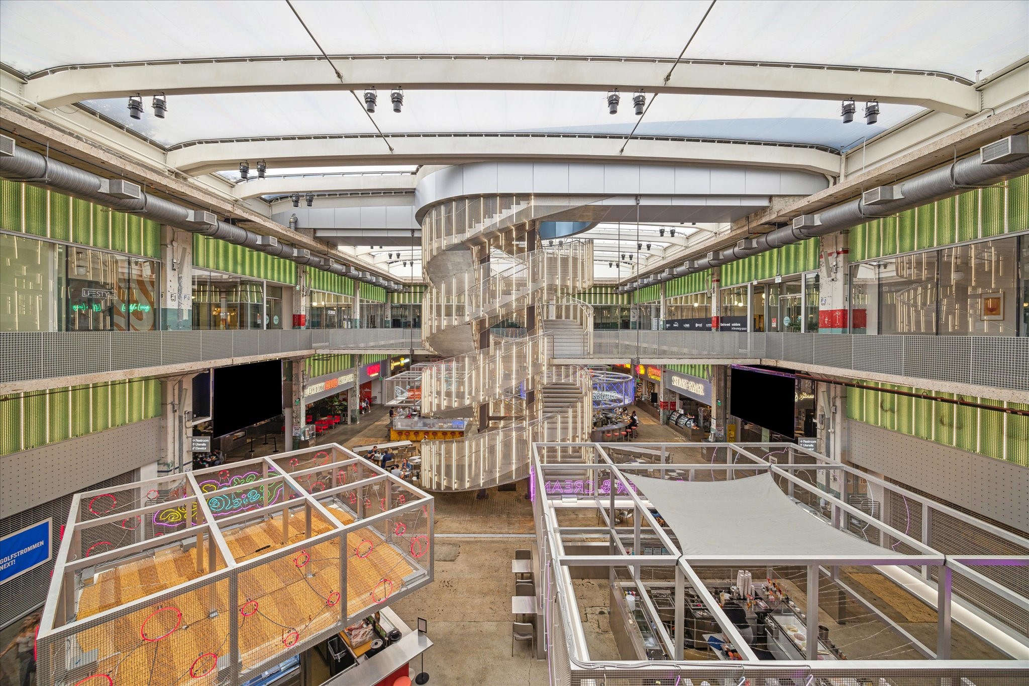 Explore this modern commercial space nearby featuring open walkways, a striking central staircase, and a bright, airy atmosphere. Perfect for retail or dining opportunities.