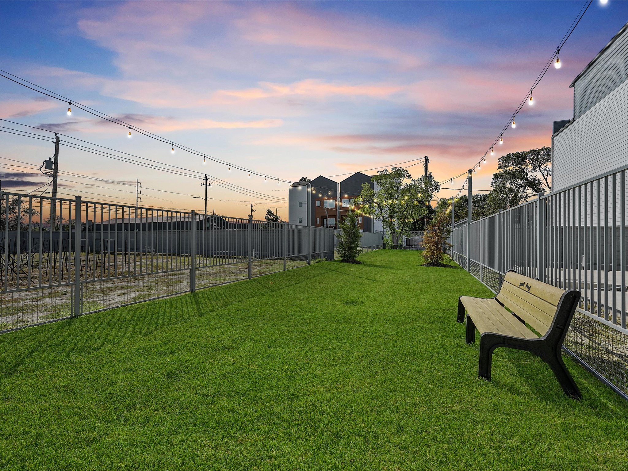 Experience delightful evenings with your furry friend in this charming dog park, complete with lush greenery and ambient string lights. Experience delightful evenings with your furry friend in this charming dog park, complete with lush greenery and ambient string lights.