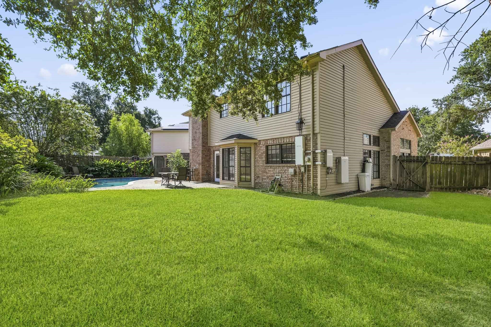 The expansive lawn offers additional green space for relaxing, recreation, or gatherings.