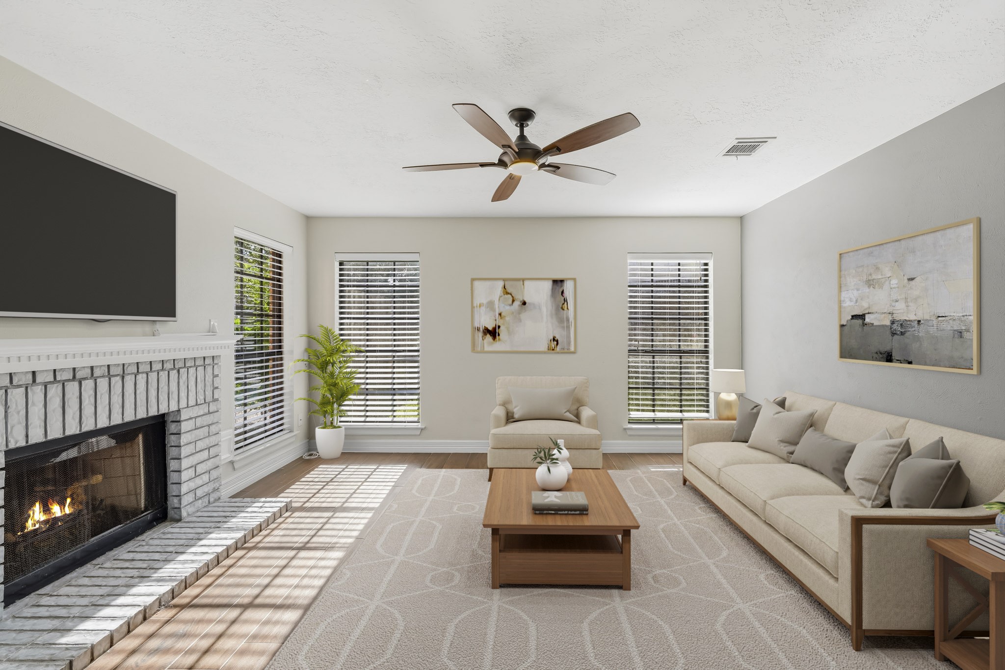 Virtually Staged: This spacious living area features warm wood-look flooring, a classic brick fireplace, and multiple large windows that fill the room with natural light. A ceiling fan adds everyday comfort, while the open layout provides plenty of flexibility for a generous seating arrangement and entertainment area.